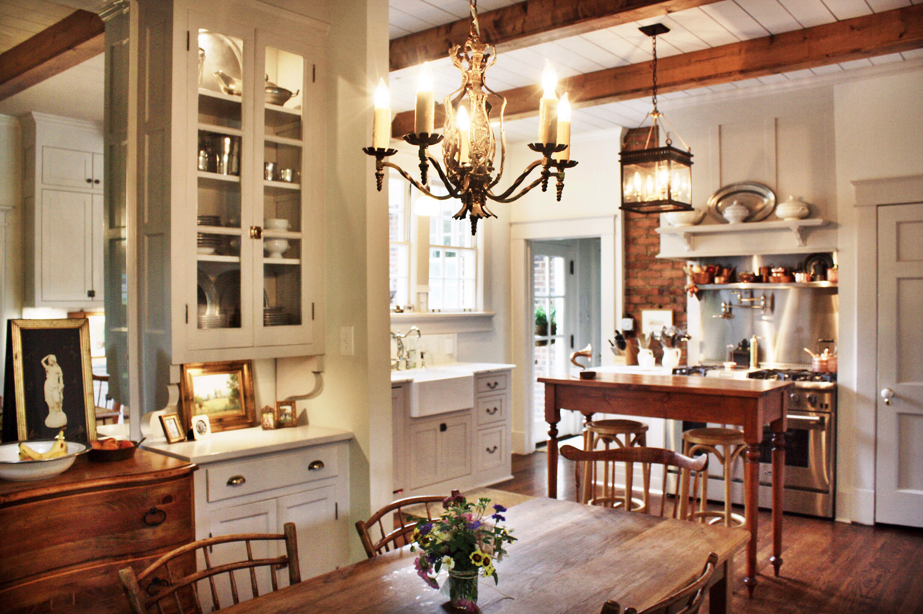 The image features a kitchen countertop with wooden cutting boards, kitchen supplies, a small potted plant, and a decorative lamp placed on a marble surface.