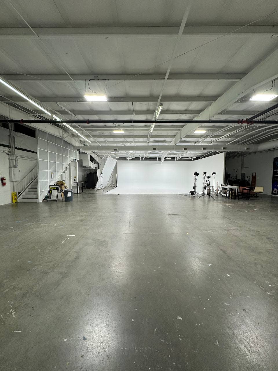 A group of individuals participates in a fitness class, performing plank exercises on yoga mats in a minimalist studio.