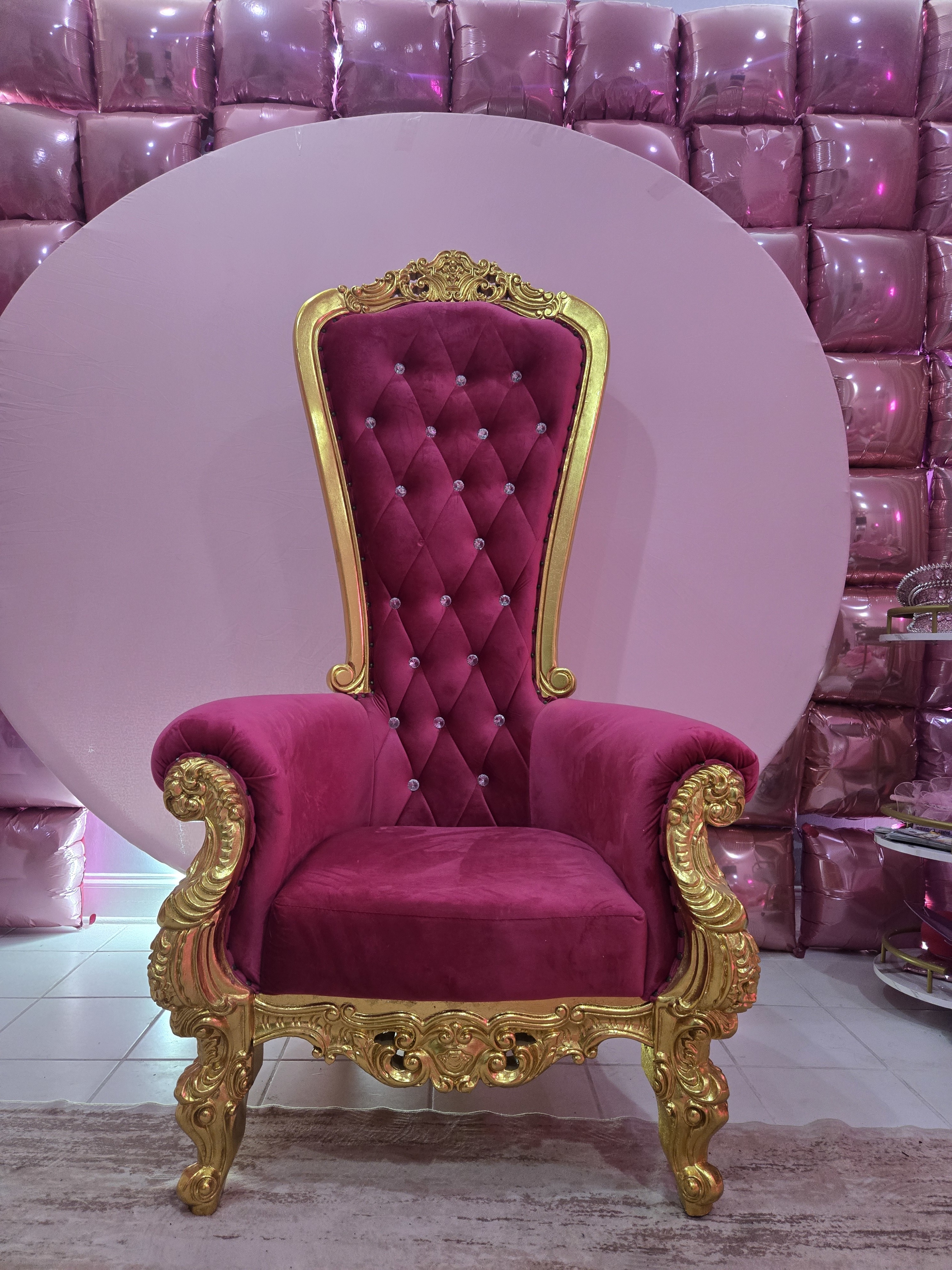 A young woman celebrates her 16th birthday by posing with a lit candle in a pink-themed photo booth.