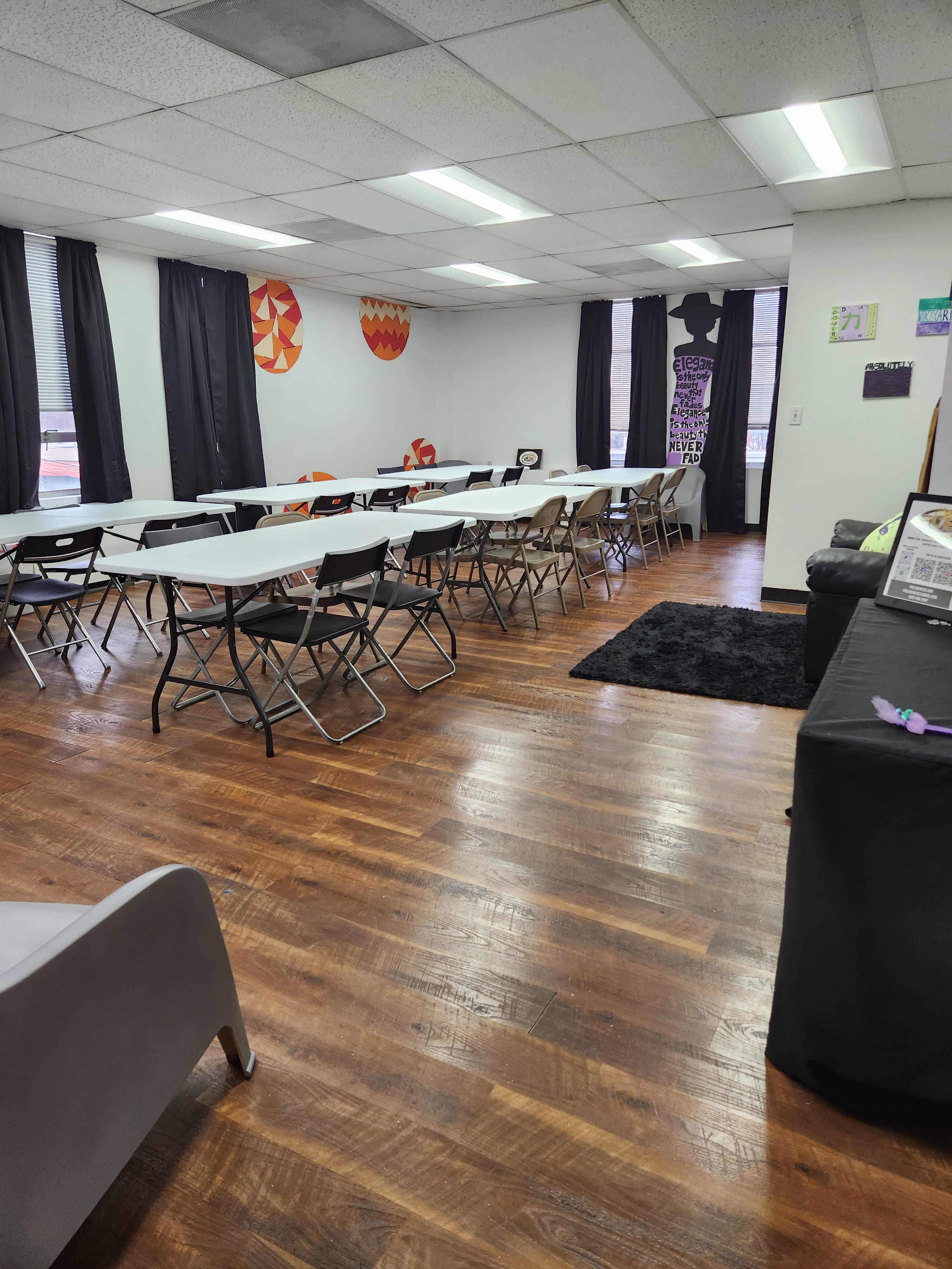 Participants gather around tables, painting vibrant portraits while enjoying beverages in a lively art studio.