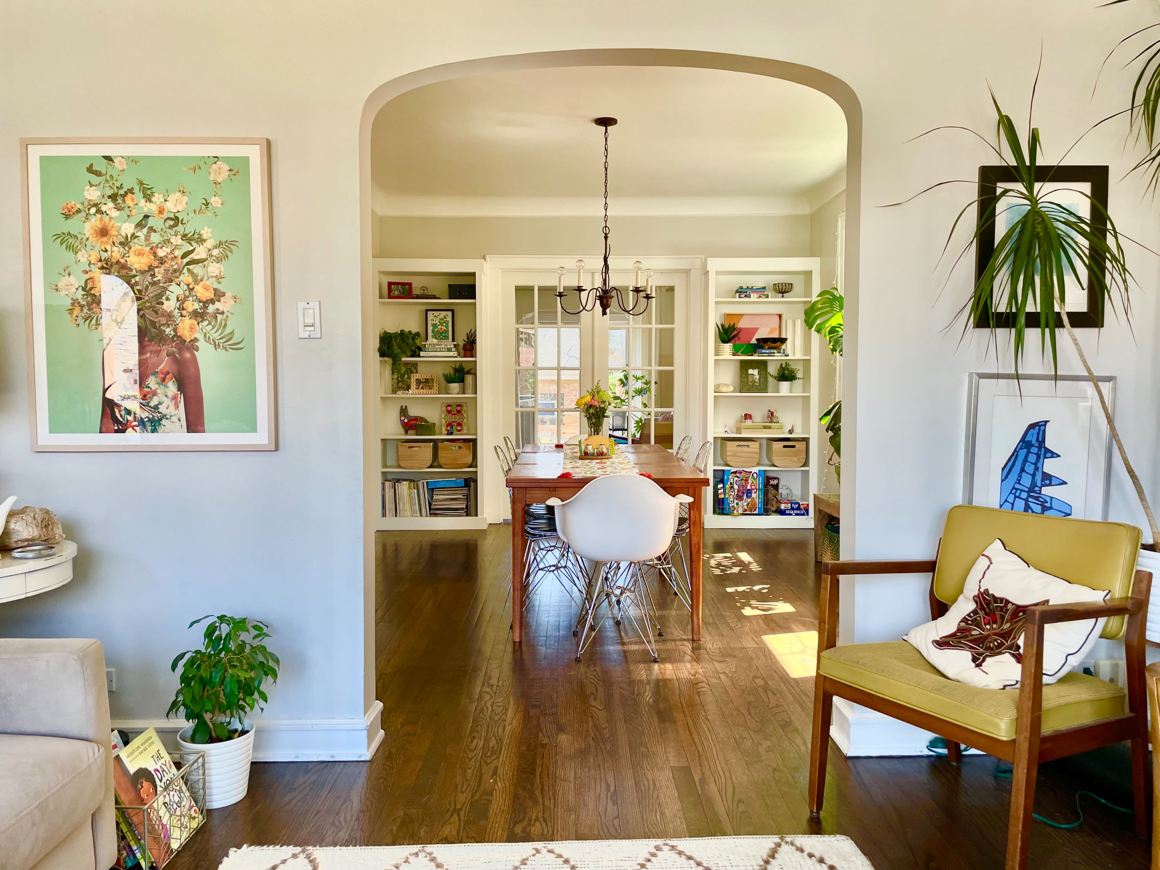 A photographer captures a woman posing in a cozy living room near a large window.