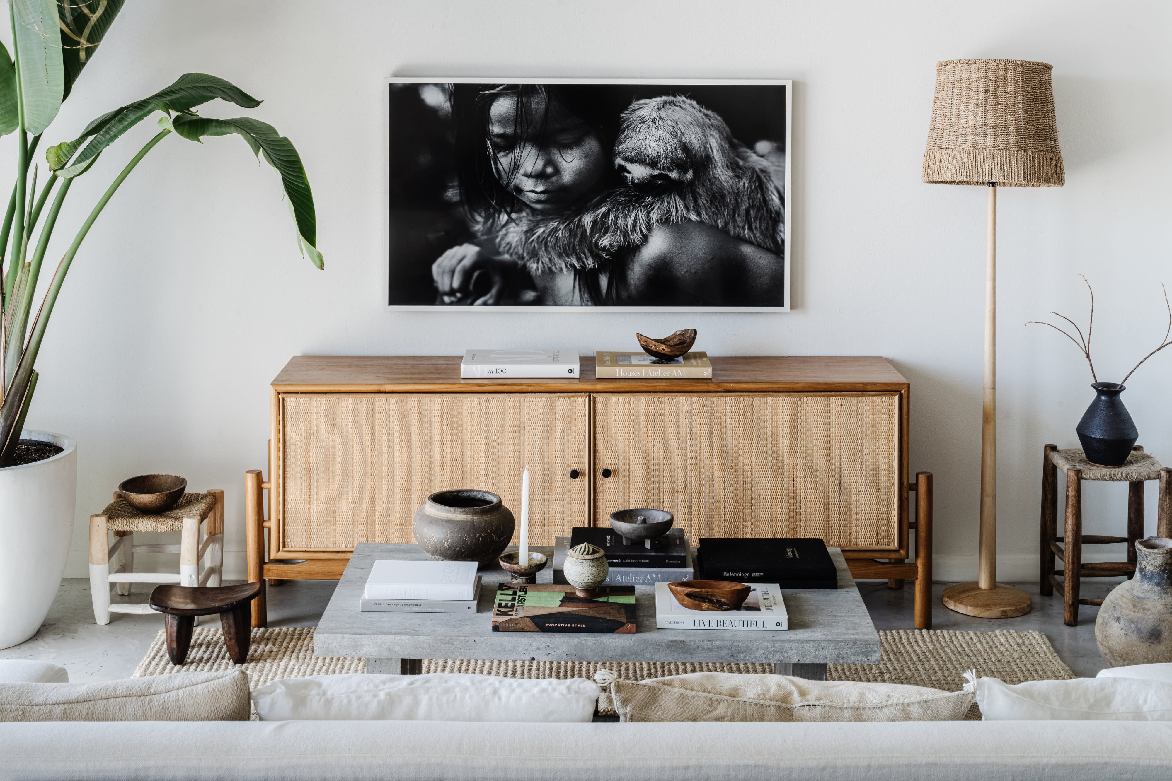 A group of children sits on a couch, engaging with one another in a bright, modern living room during a family photo shoot.