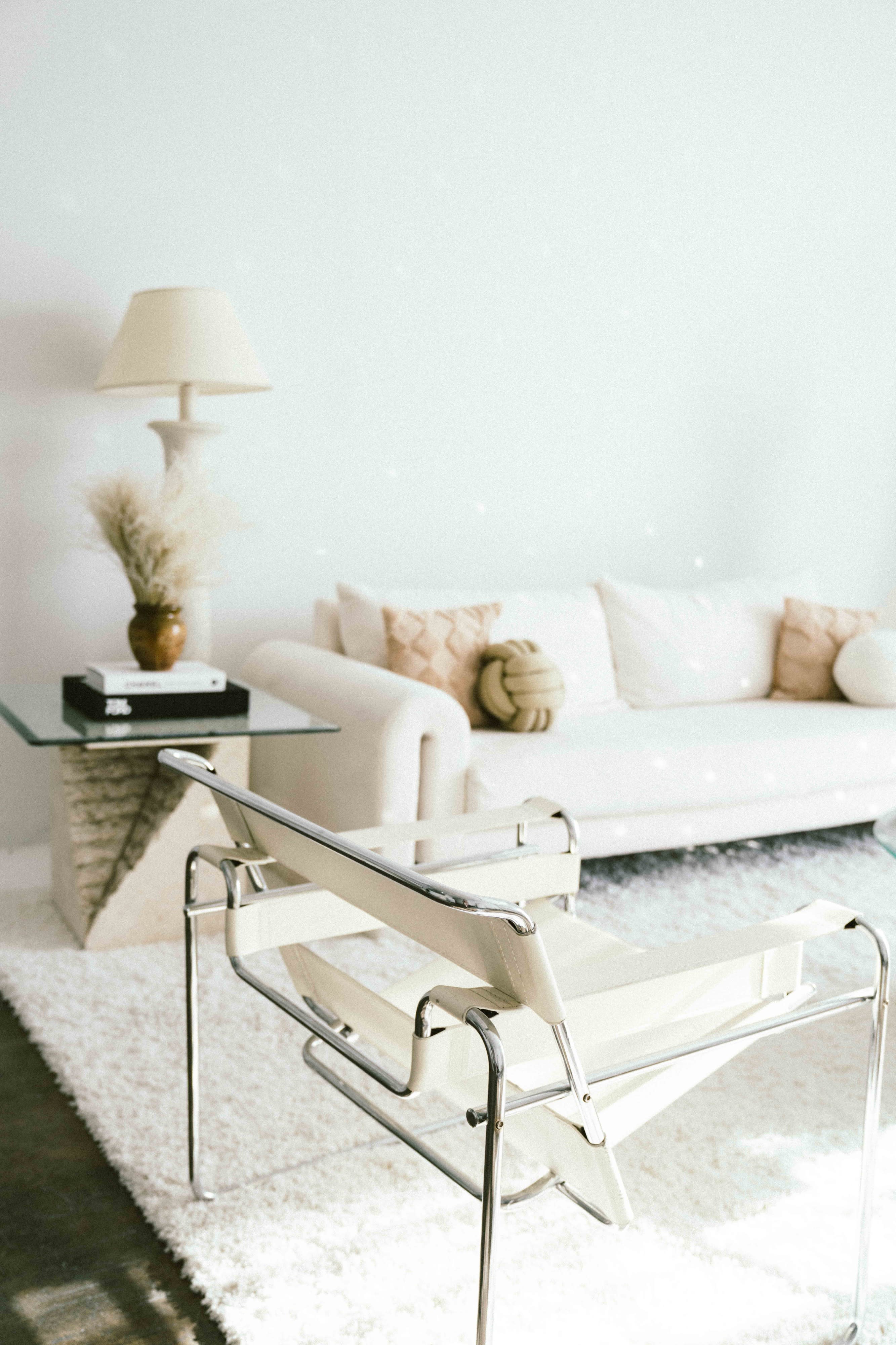 A glass coffee table displays various jewelry pieces, decorative objects, and magazines arranged aesthetically.