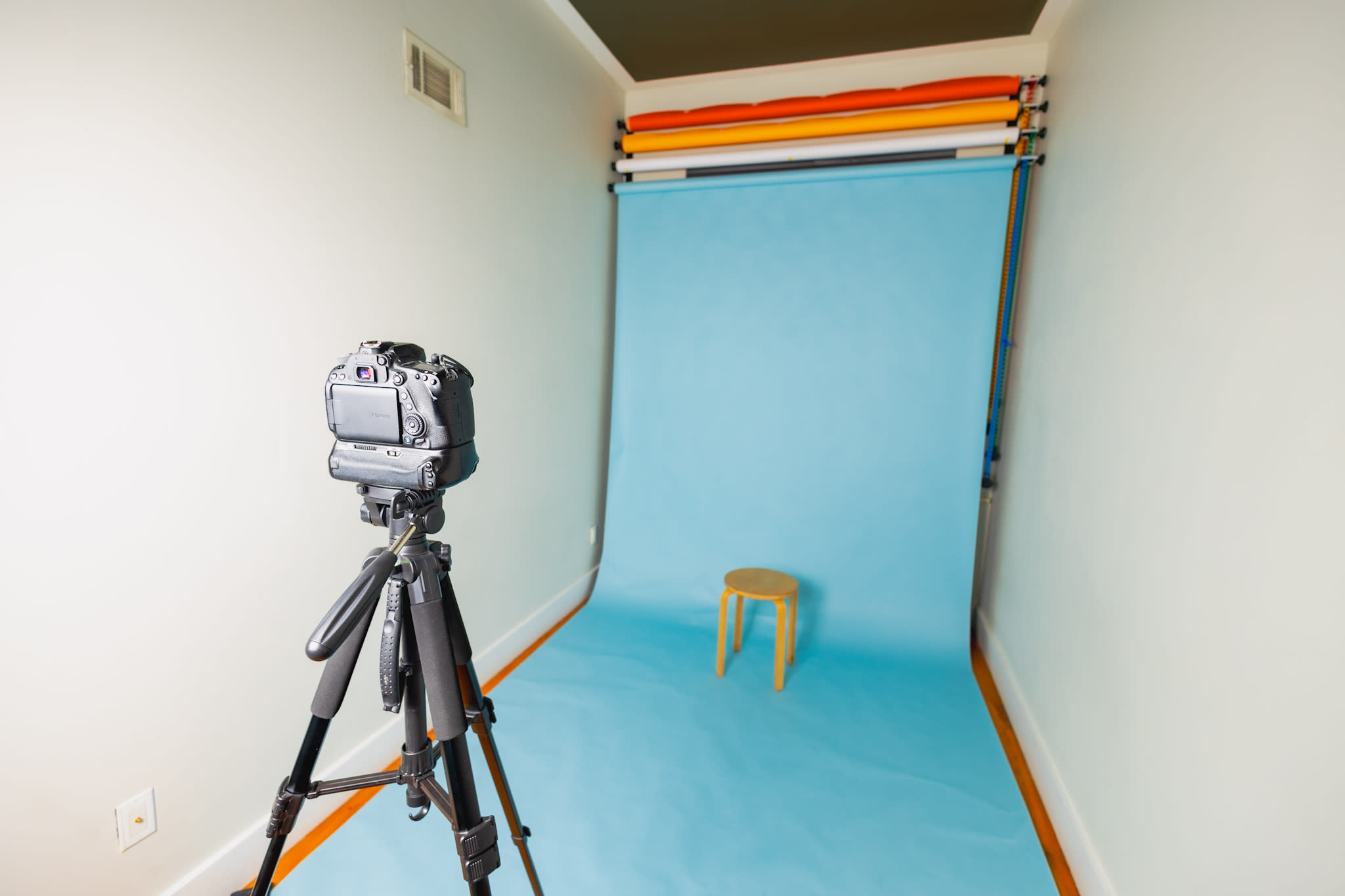 A person wearing a party hat smiles while posing for a photo against a blue background.