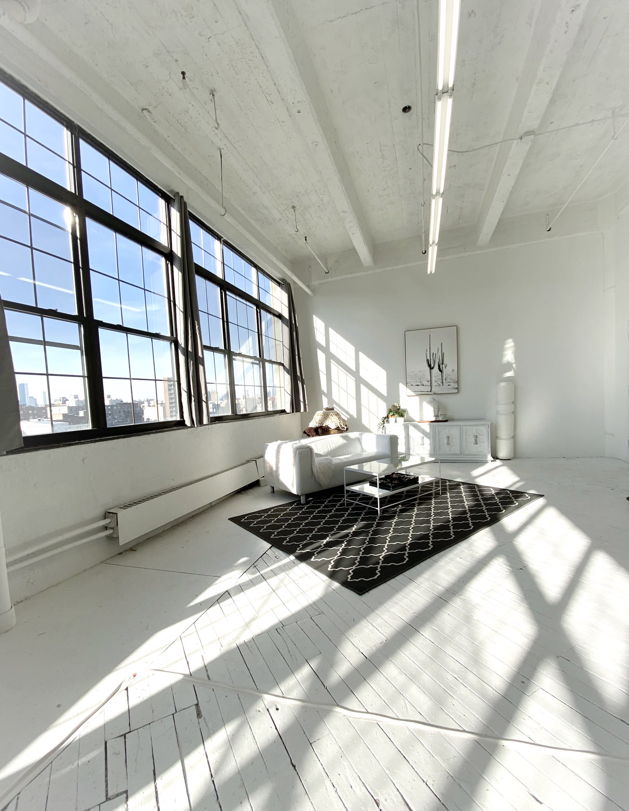 A model poses with an elegant updo and intricate headpiece, showcasing a fashion ensemble with a fitted bodice and a flared skirt.