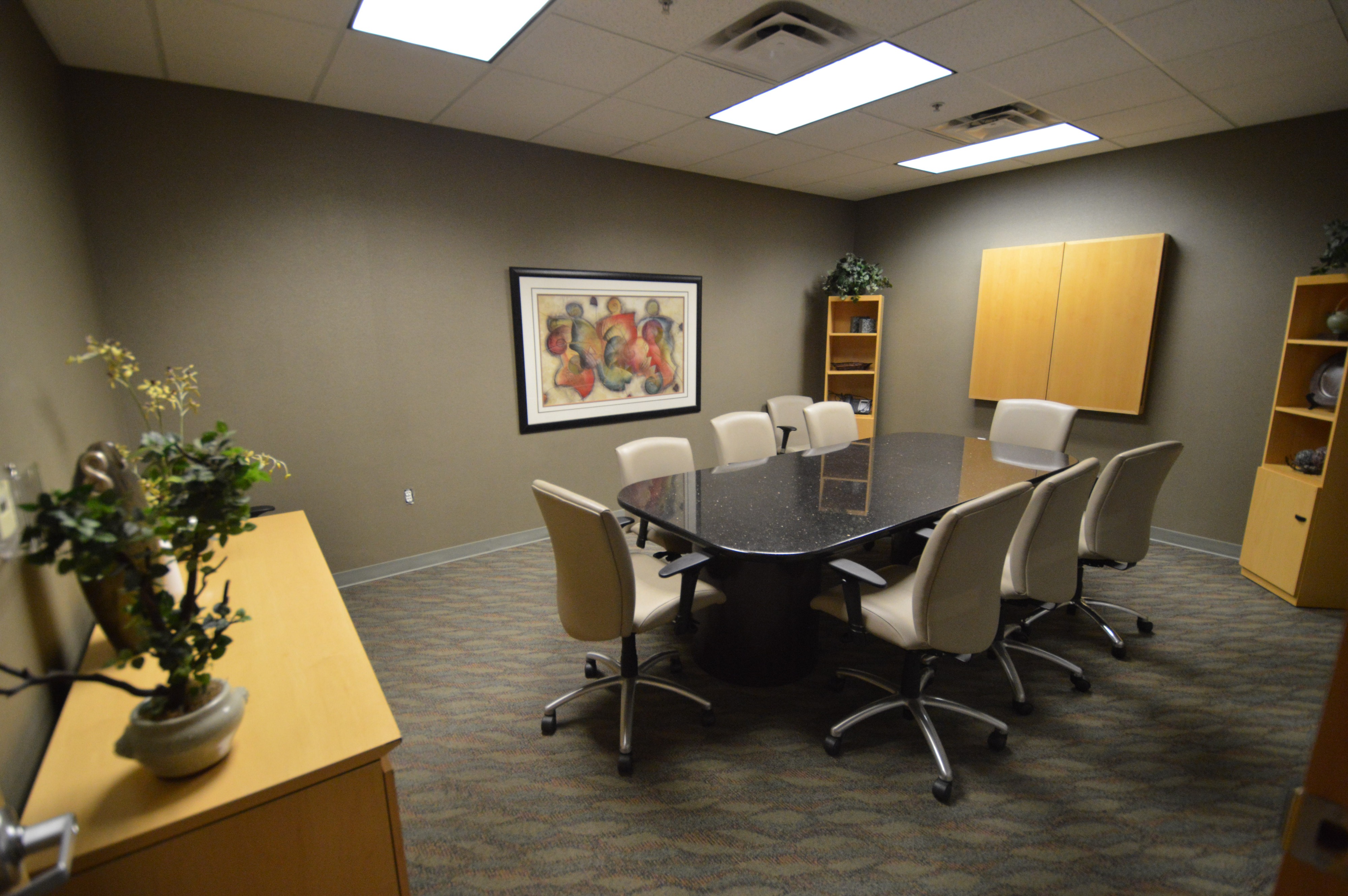 A group of individuals participates in a table reading session, reviewing scripts and taking notes around a conference table.