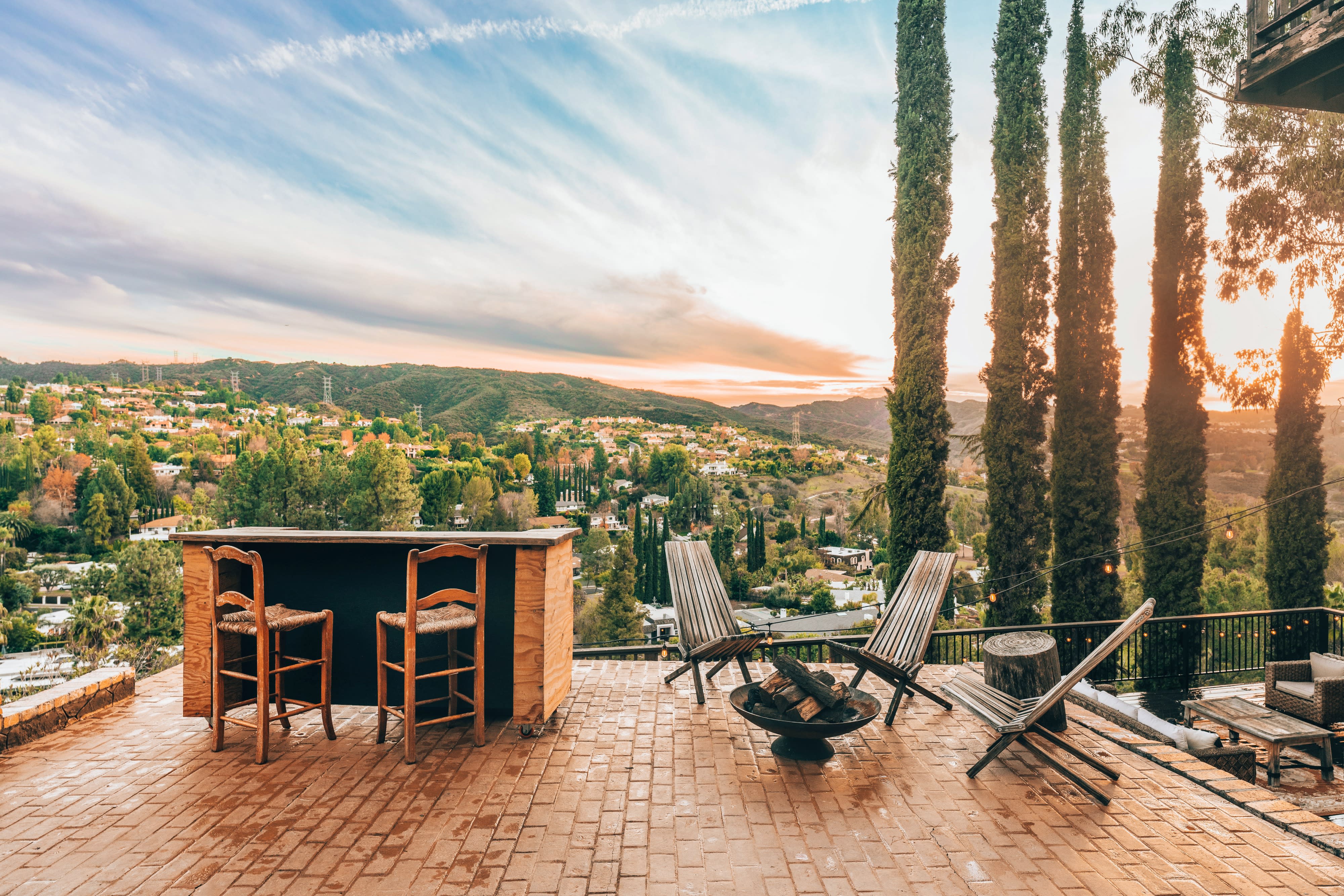Guests enjoy a dinner event on a scenic outdoor balcony, surrounded by tables adorned with floral arrangements and candlelight.