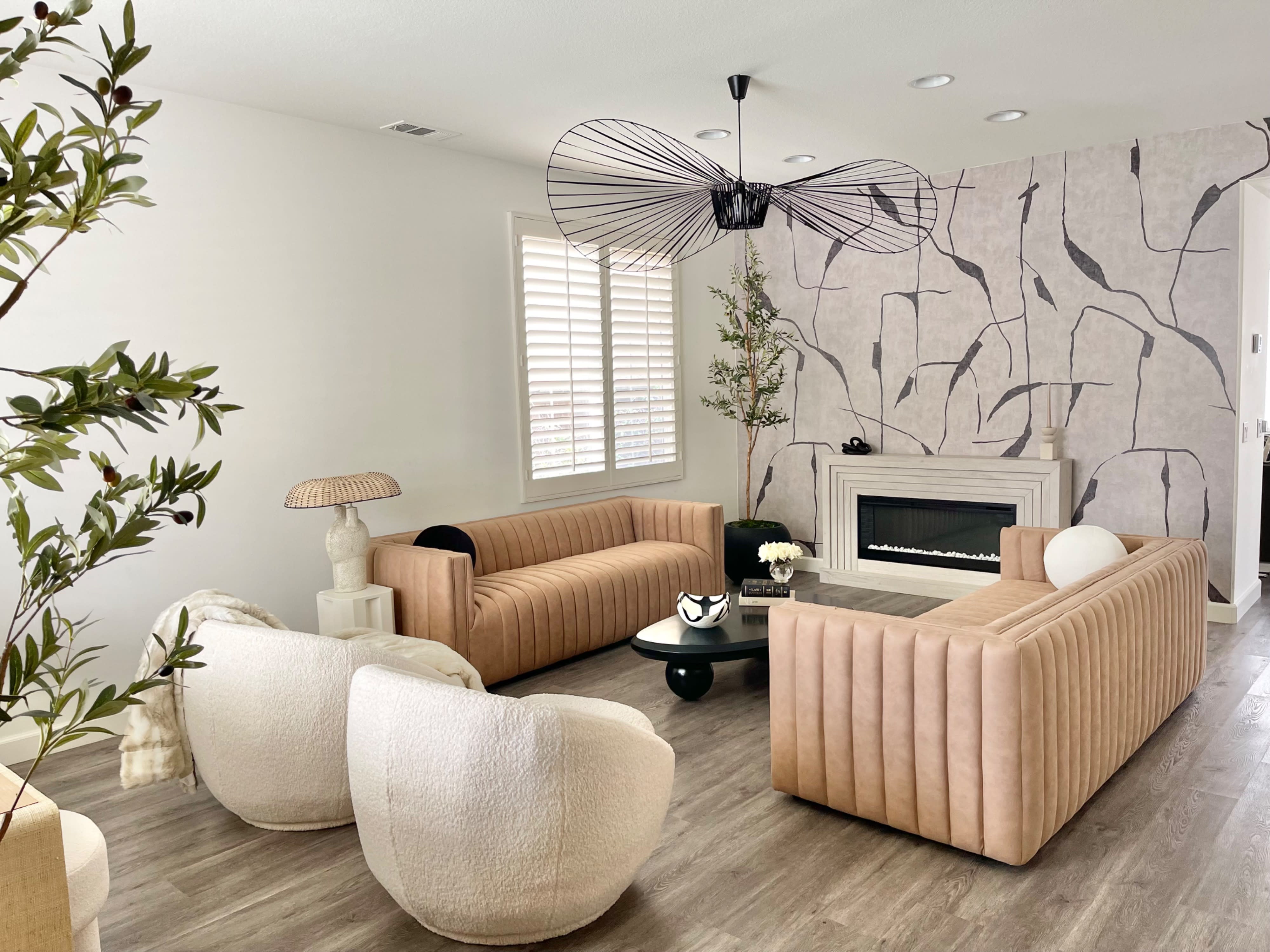 The living room is decorated for a birthday party, featuring golden balloons shaped like the number 33 and a cozy fireplace amidst modern furnishings.