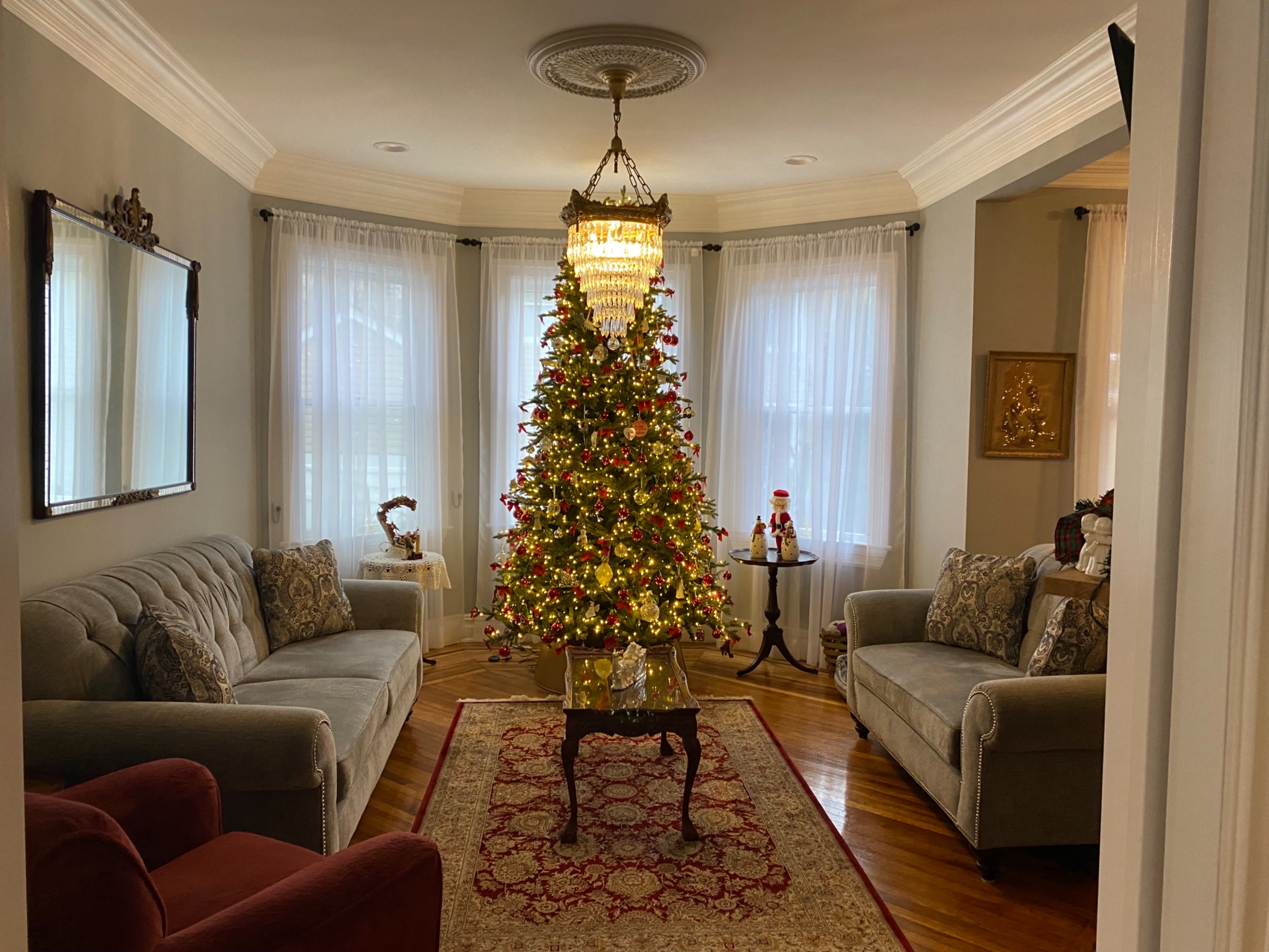 A couple poses for a wedding photo shoot in a living room with elegant decor and natural light.