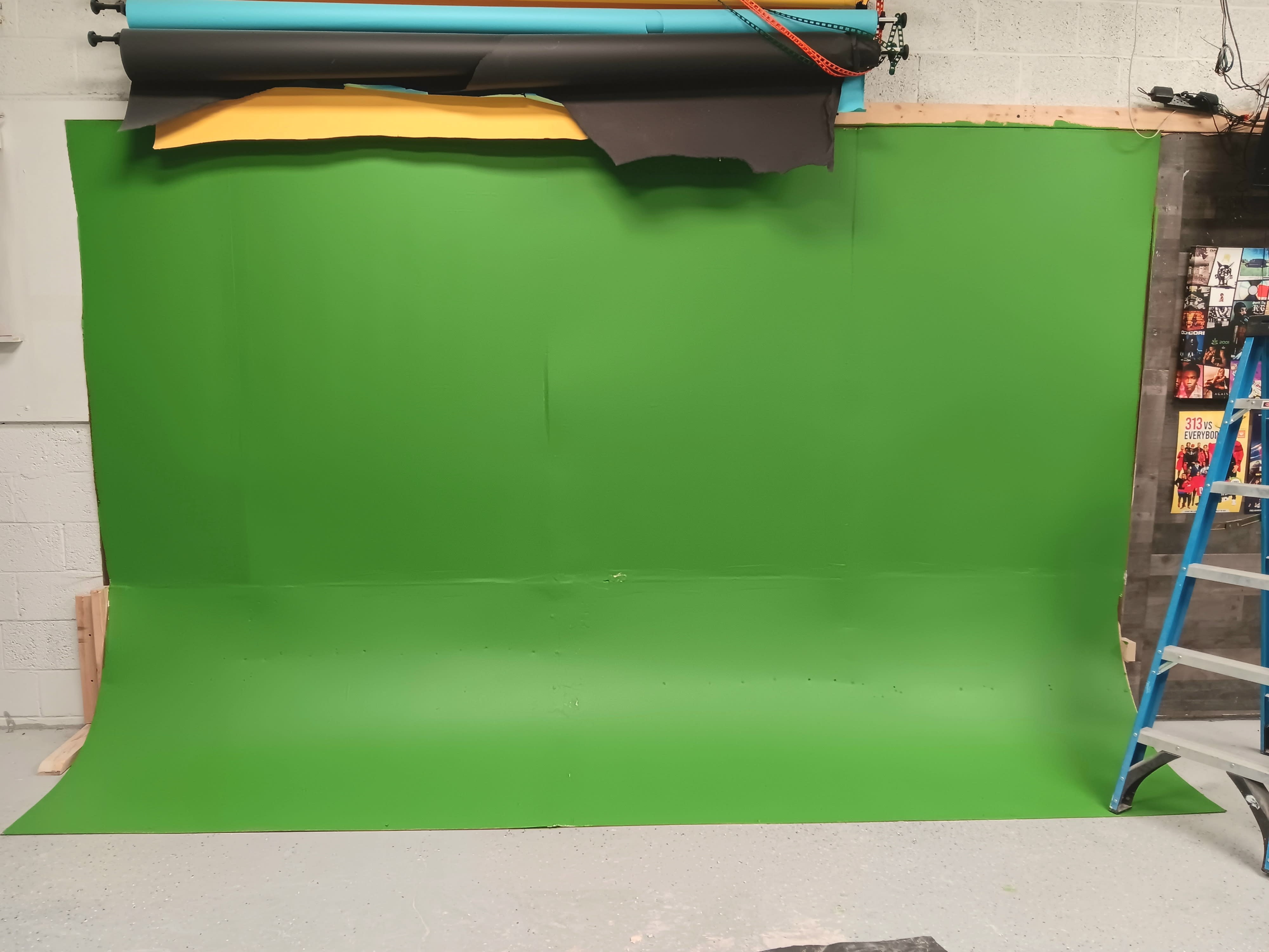 A man holds a film clapperboard while seated in a director's chair during a film shoot.