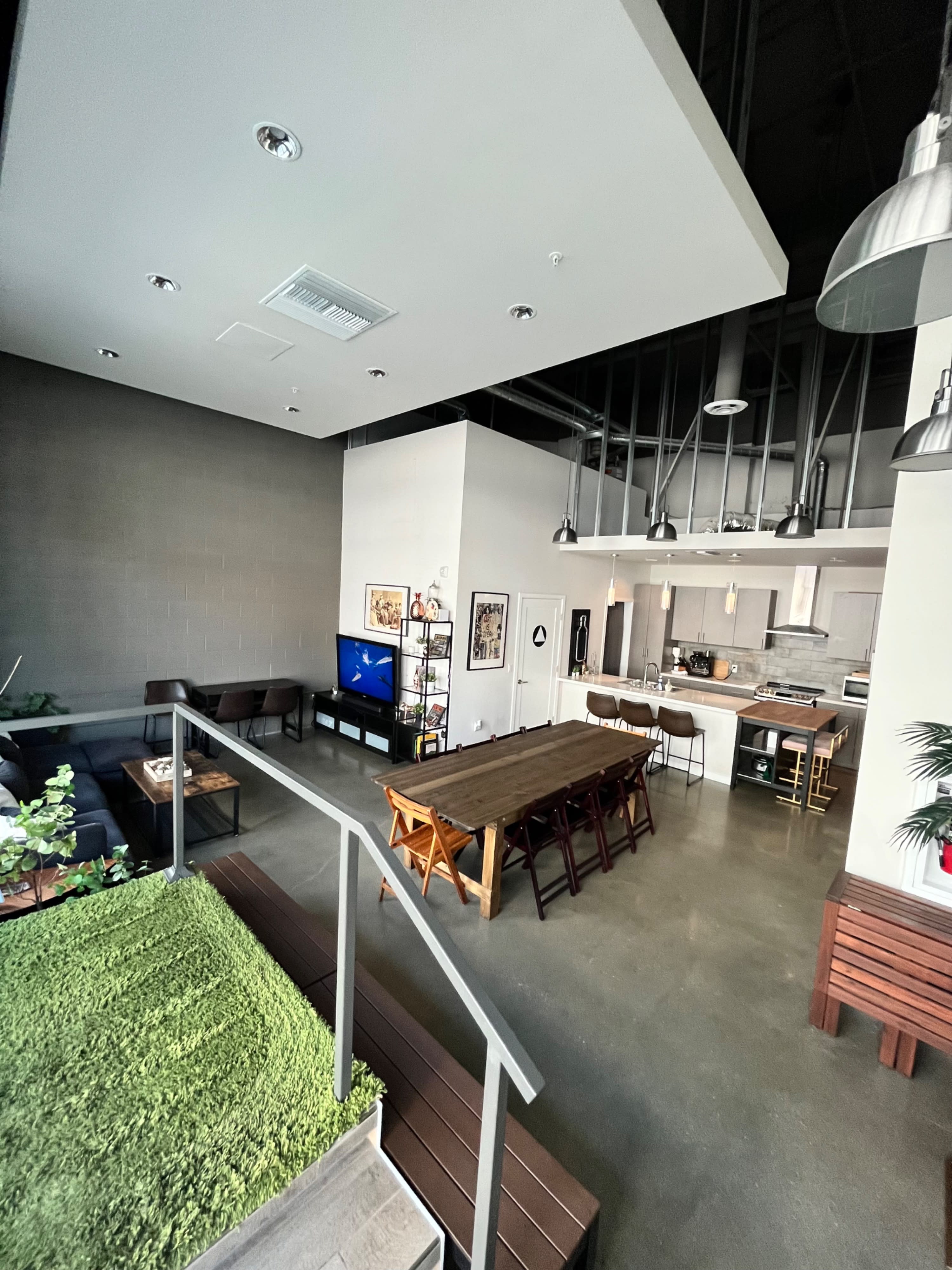 A woman is standing near a table set for brunch in a modern space with greenery on the wall.