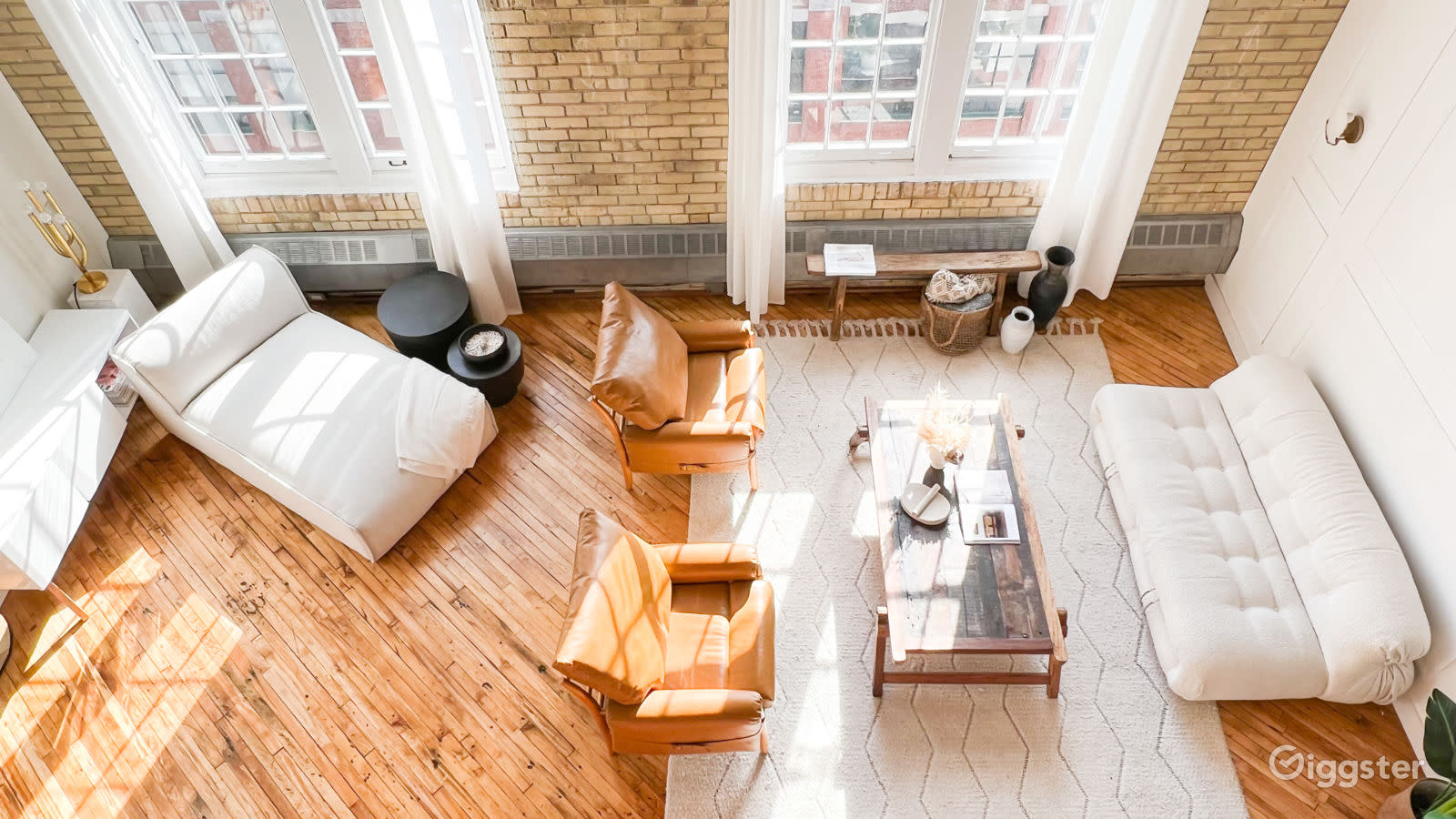 A photographer captures images of a model seated in a stylish, well-lit interior.