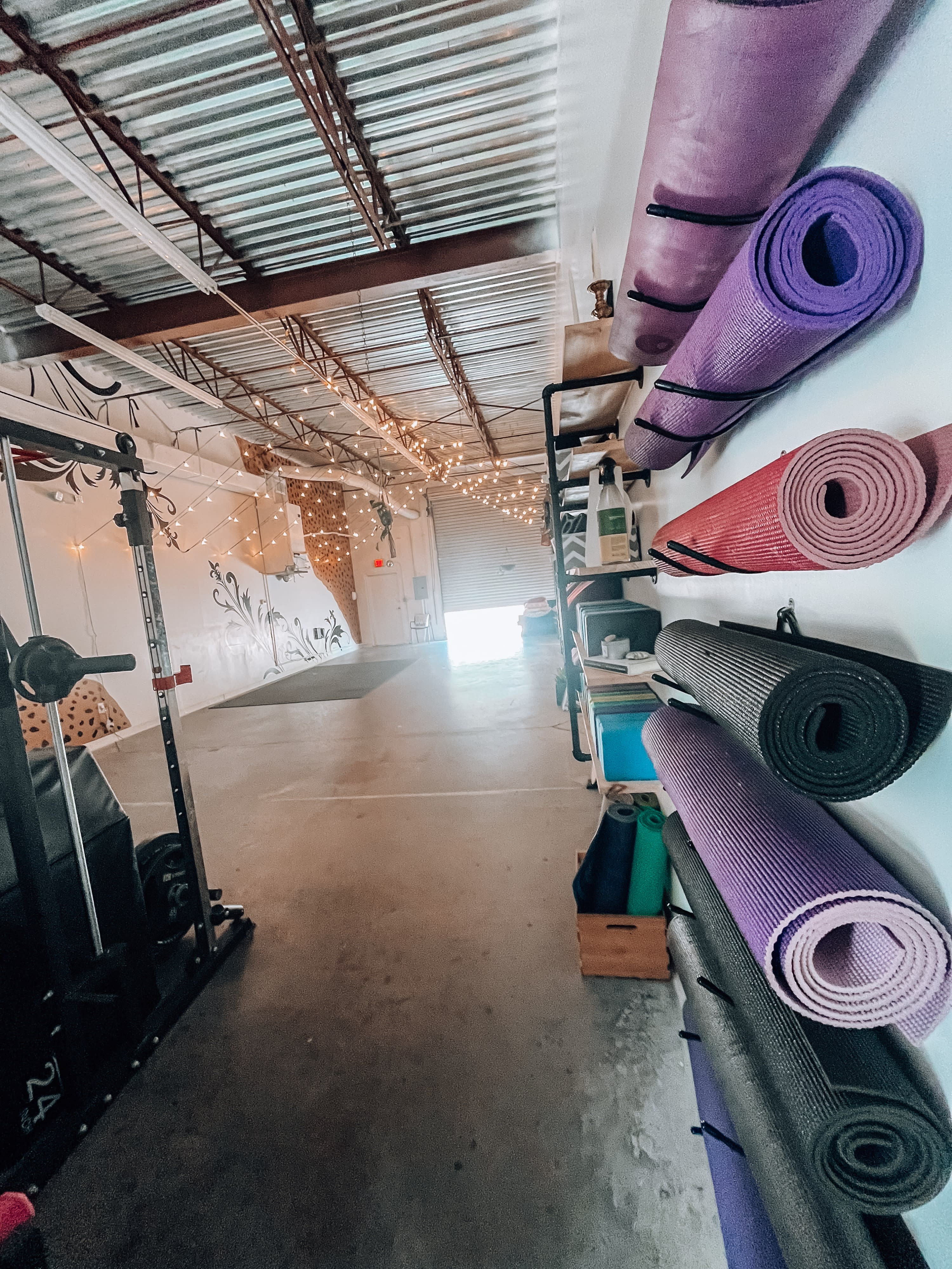 A group of participants performs exercises on yoga mats while an instructor leads the workout class in a spacious studio.