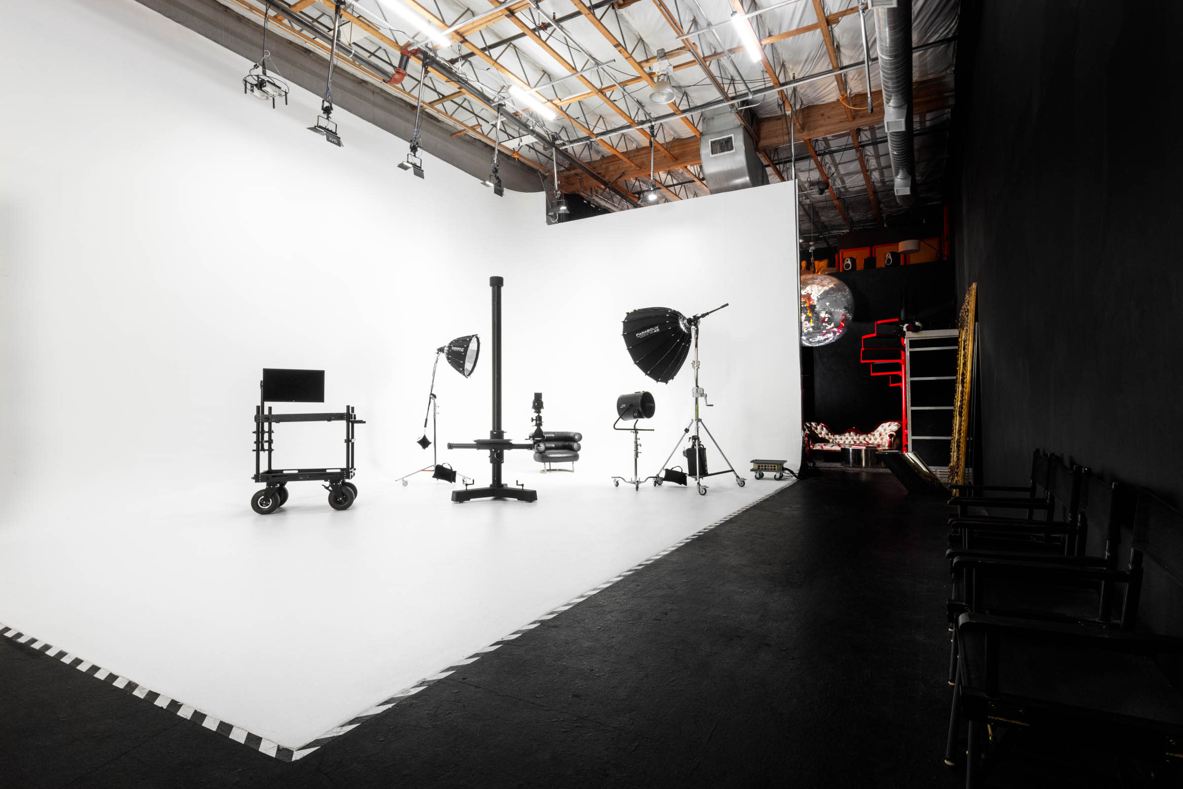 A photography studio is set up for an apparel shoot, featuring a backdrop, a lighting setup, and a tripod.
