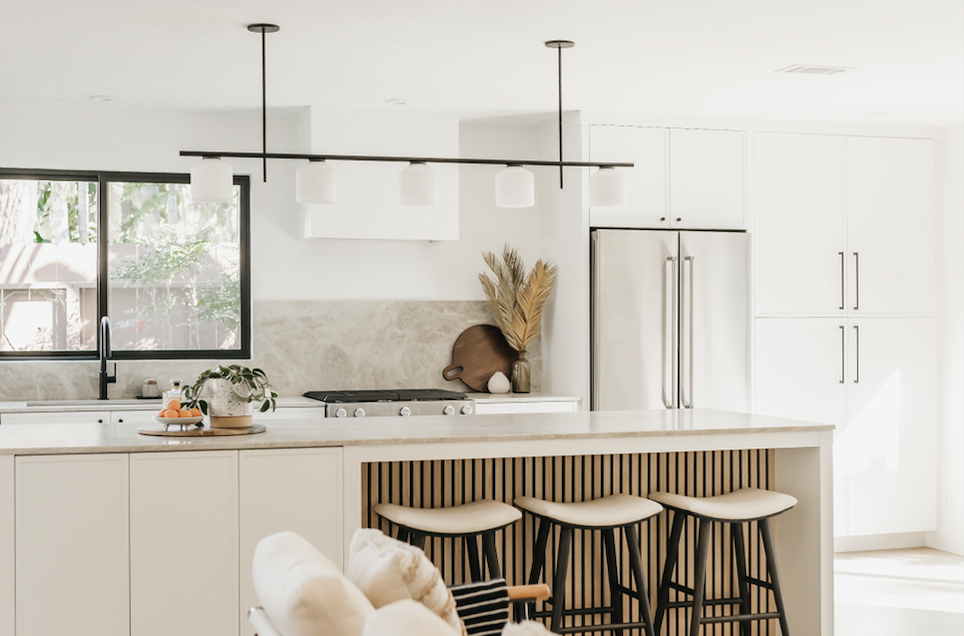 A couple dances joyfully in a bright kitchen, creating a lively atmosphere during their photo shoot.