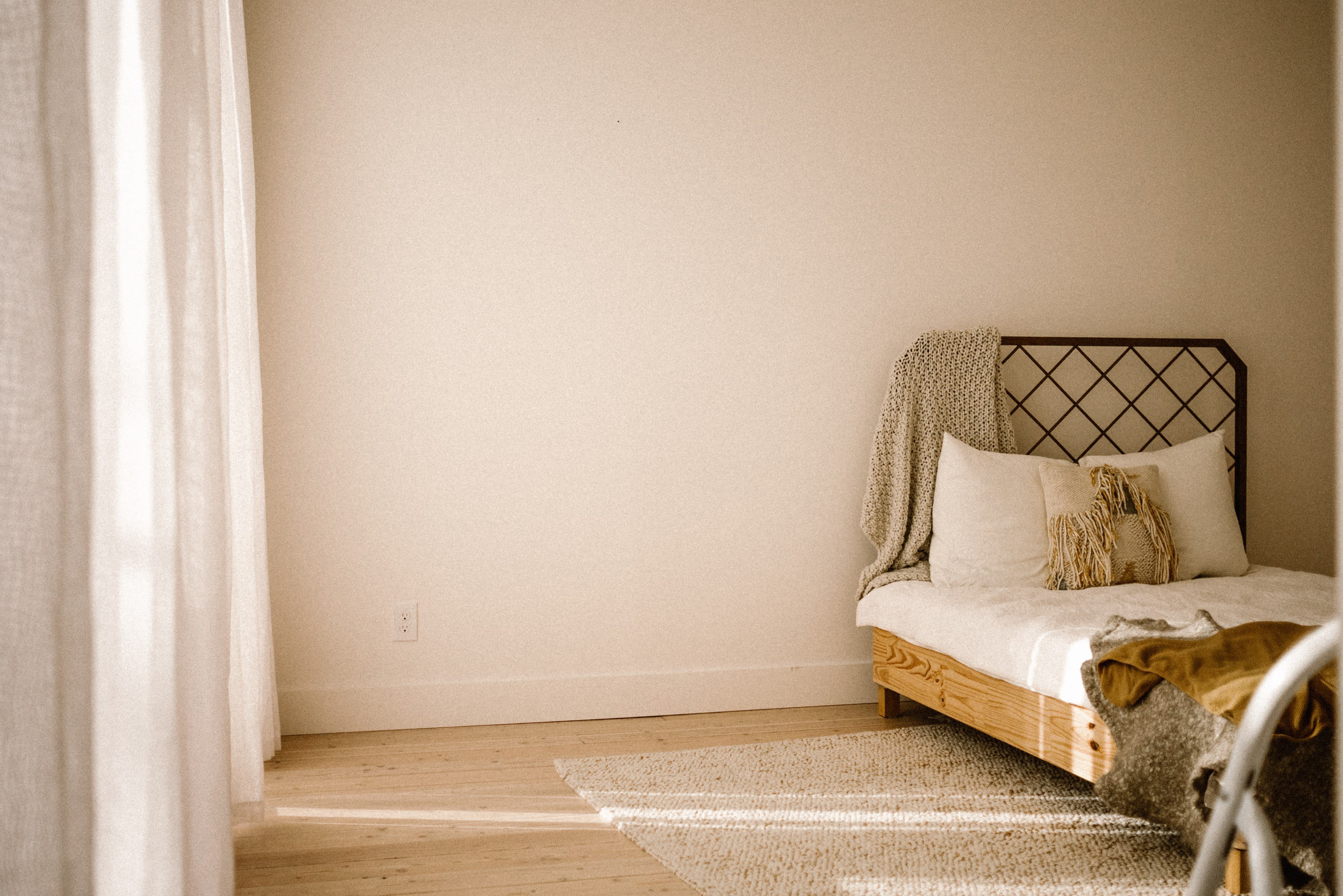 A pregnant woman poses with her partner and young child in a serene indoor setting for a maternity photo shoot.