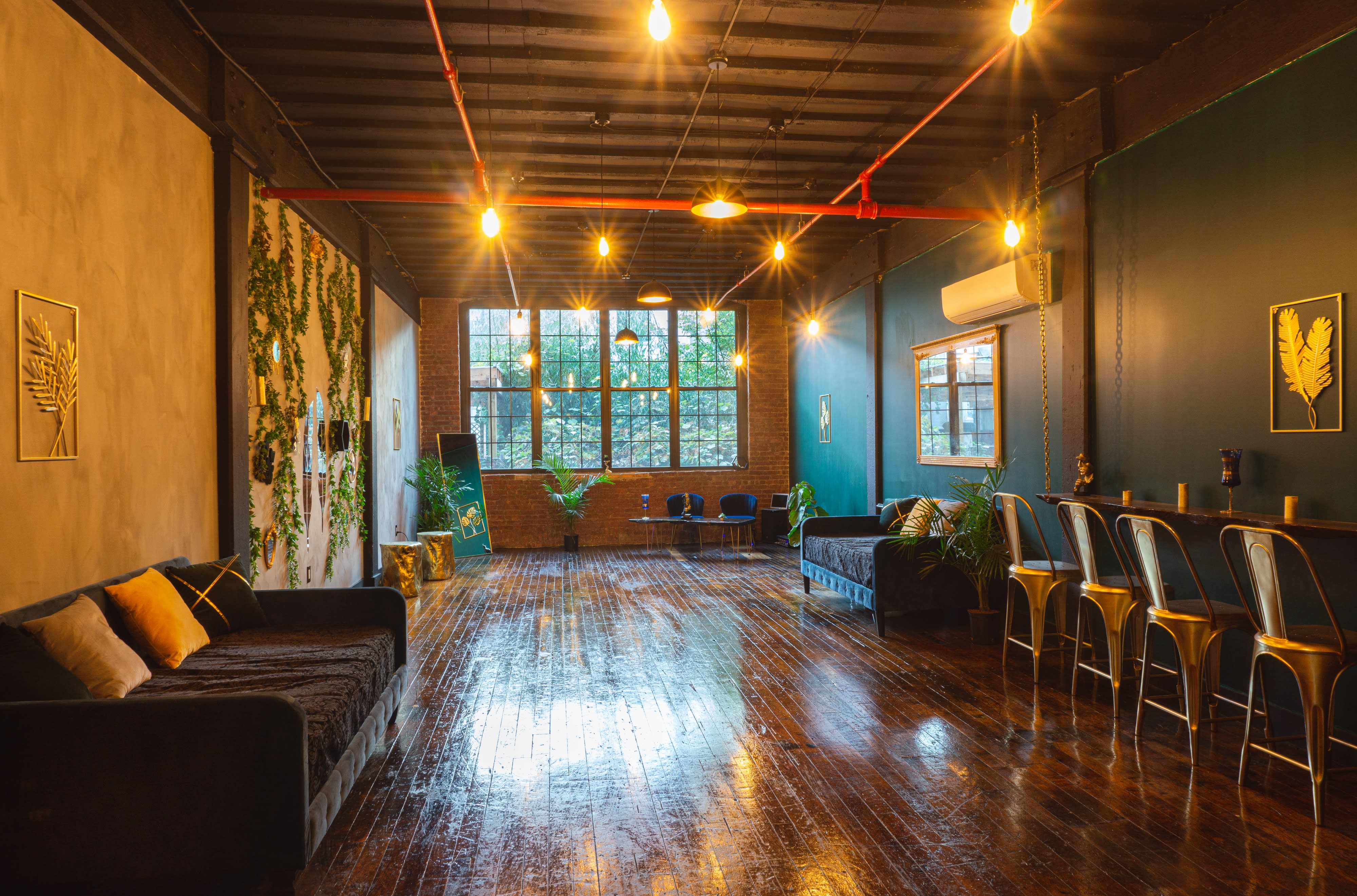 A decorated indoor space features tables set with tableware and greenery, ready for a party celebration.