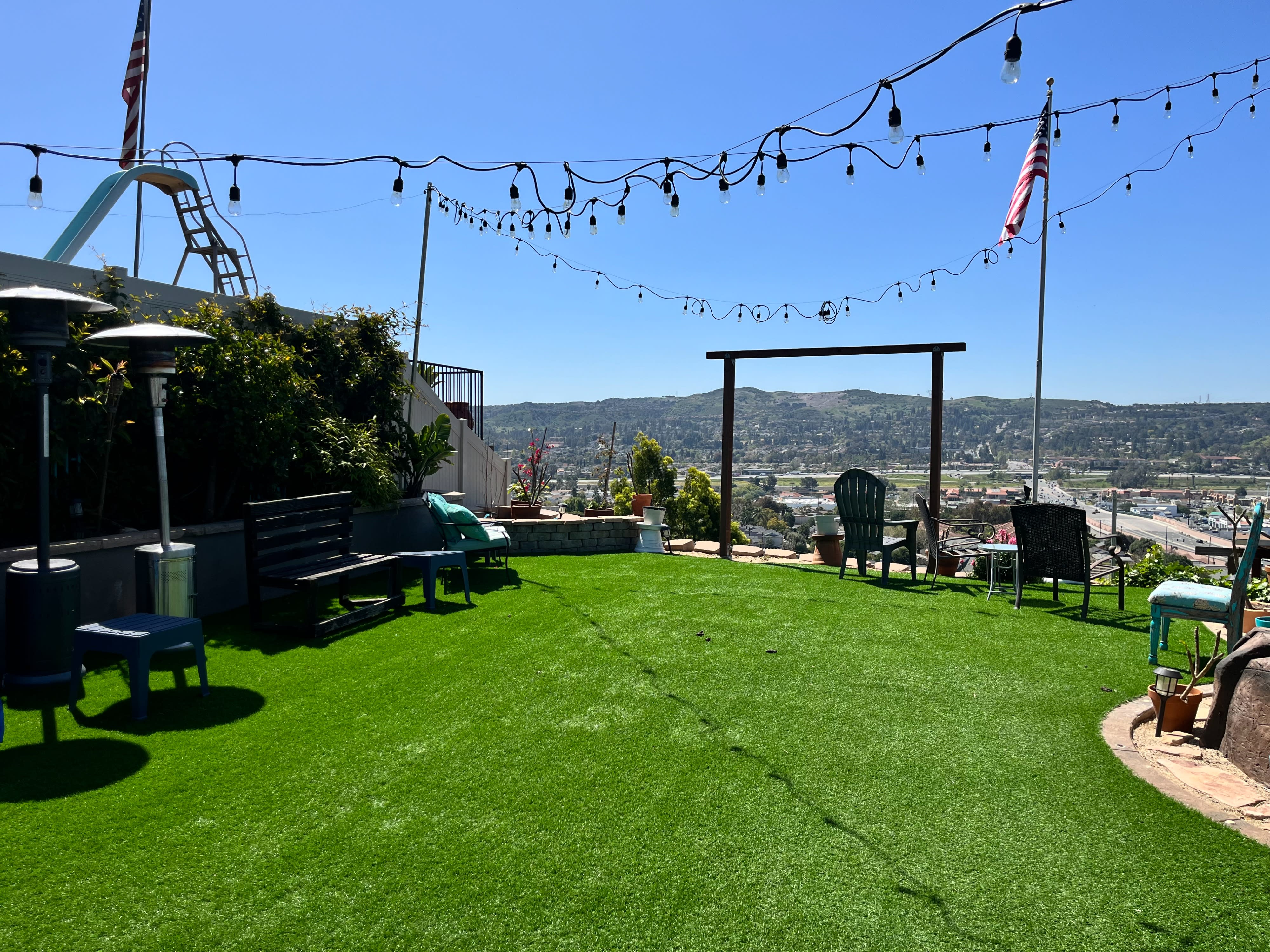 A scenic outdoor setup features a "Cheers to 50 Years" banner with large gold balloons shaped like the numbers 5 and 0, overlooking a landscape view.