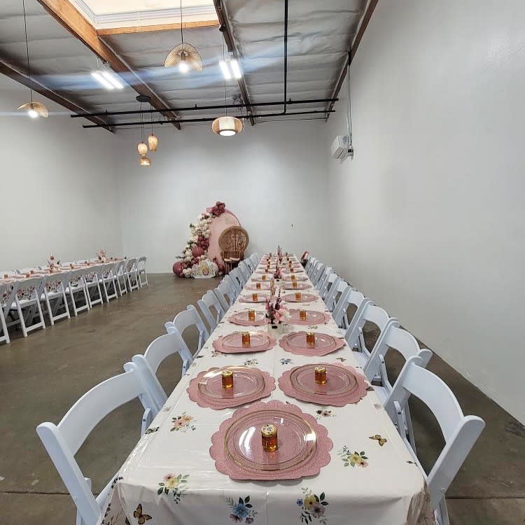The space is set up for a first birthday party with black tables, gold decorations, and a wall display that reads "IT WAS ALL A DREAM."
