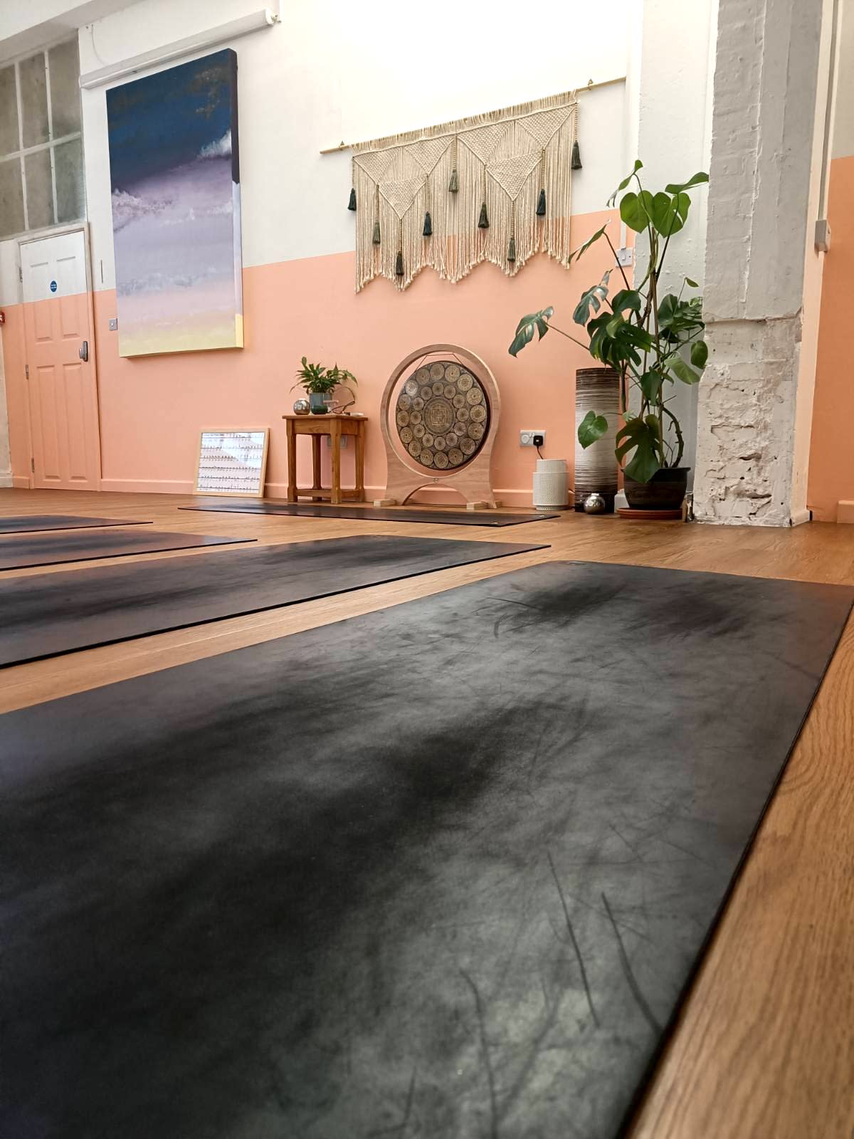 A person performs a headstand on a yoga mat in a well-lit indoor space.