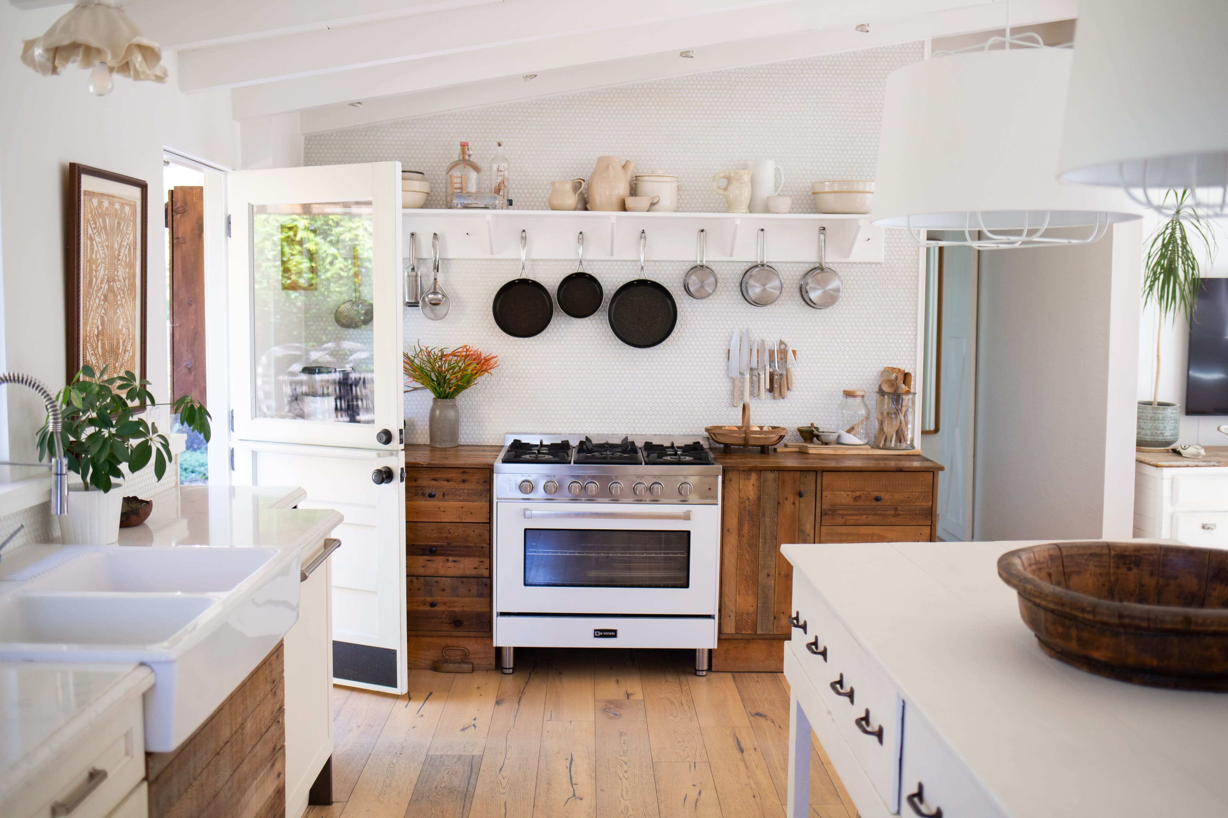 A photographer captures a model posed in a well-lit kitchen during a photo shoot.