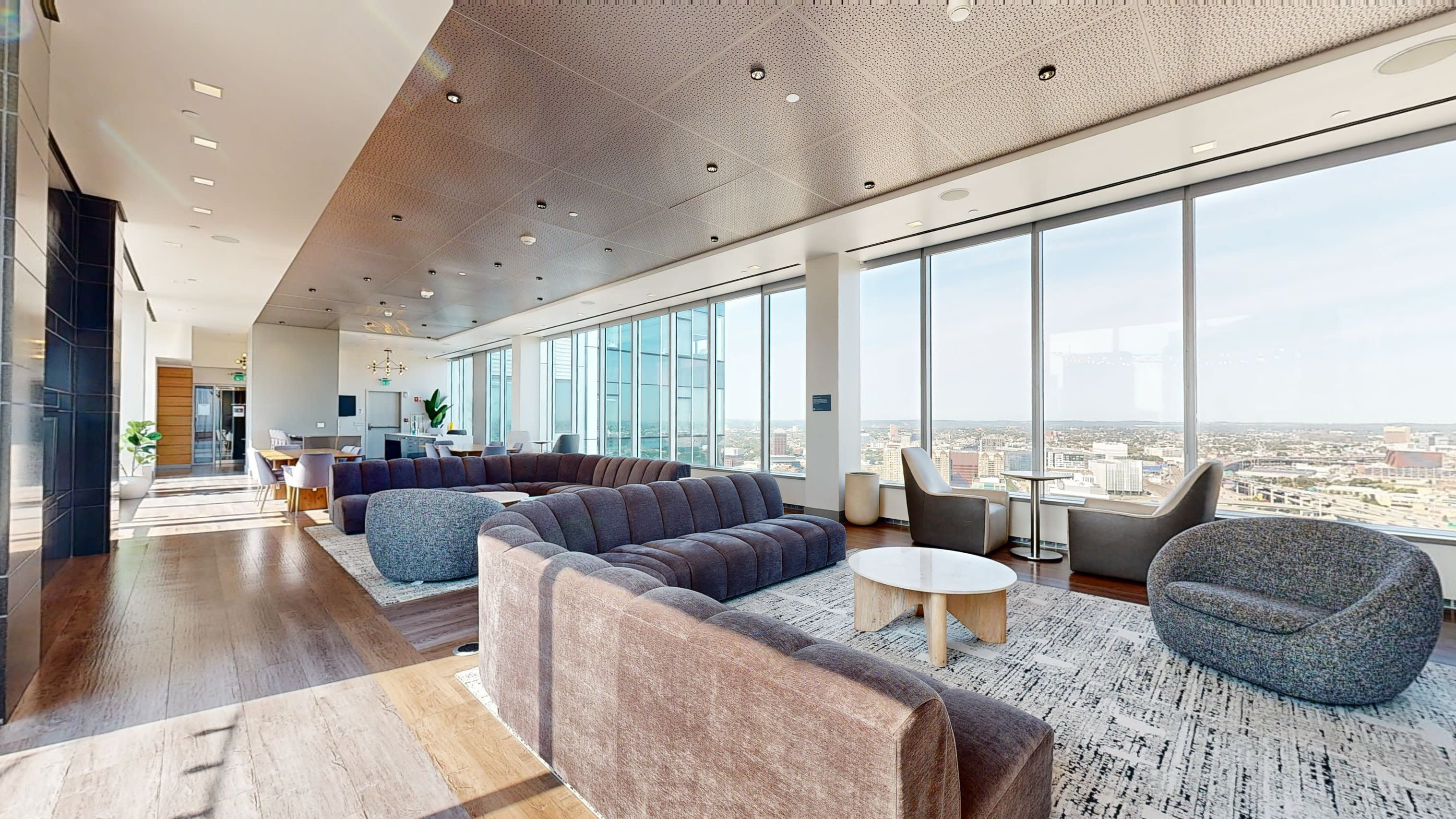 A panel of speakers engages an audience during a networking event held in a modern, bright room with large windows.