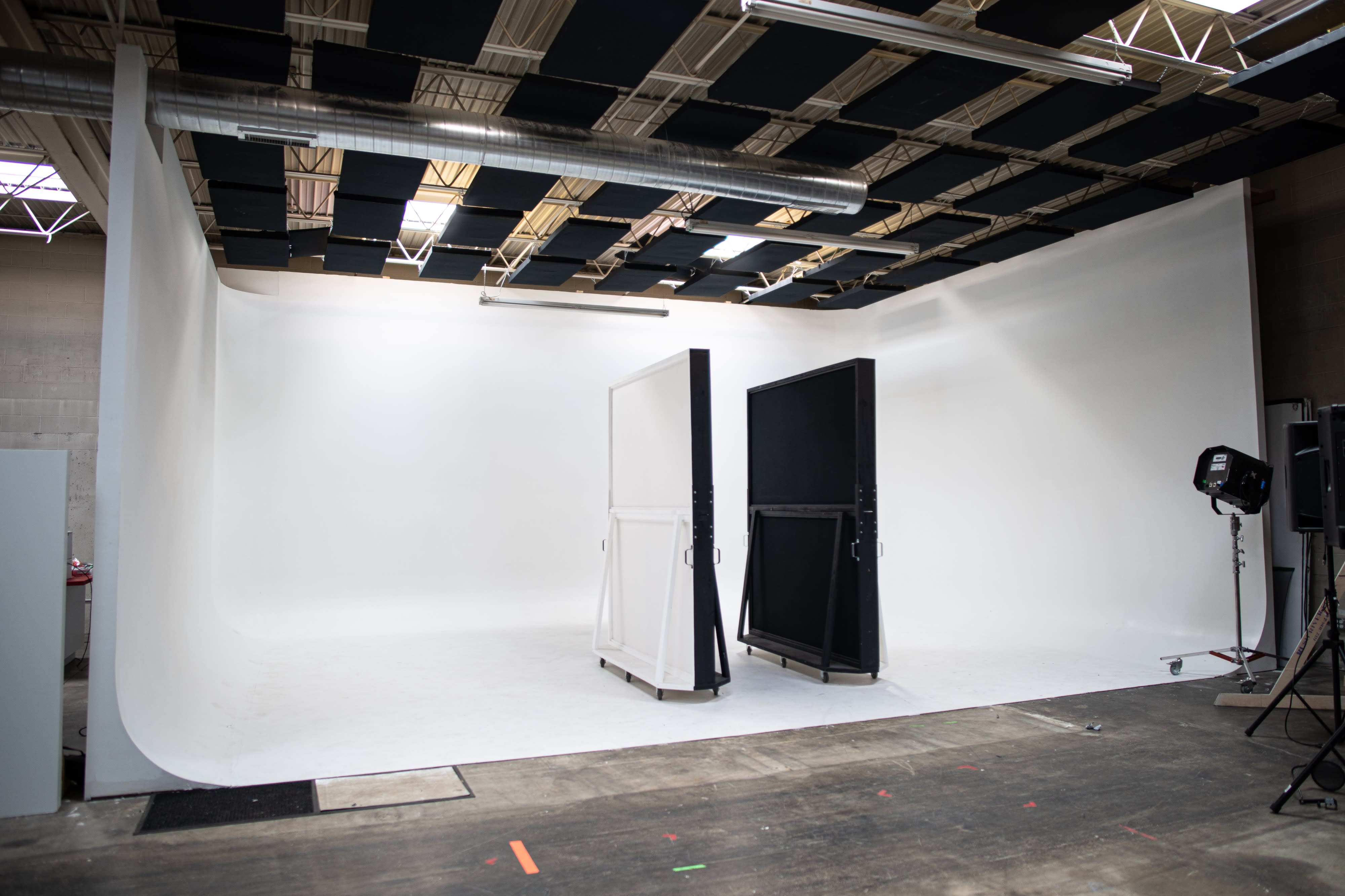 Four women pose together in a studio setting for a video shoot, dressed in stylish outfits that reflect a bold fashion aesthetic.
