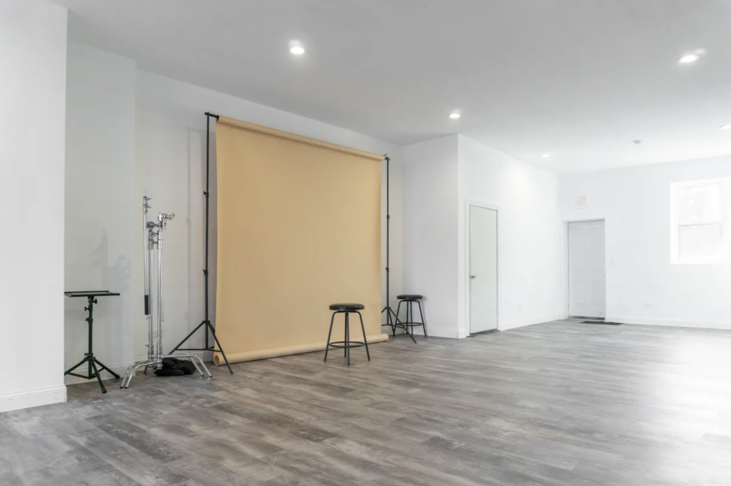 A photography setup features a single flower placed on a table, surrounded by camera equipment and studio lighting.