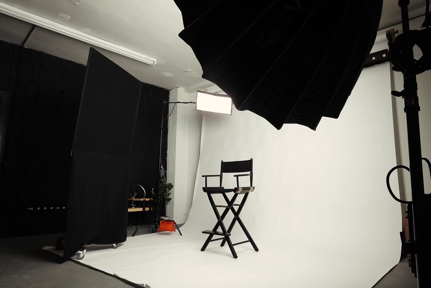 A camera crew is set up in a studio while a woman in athletic attire prepares to perform in front of the backdrop.