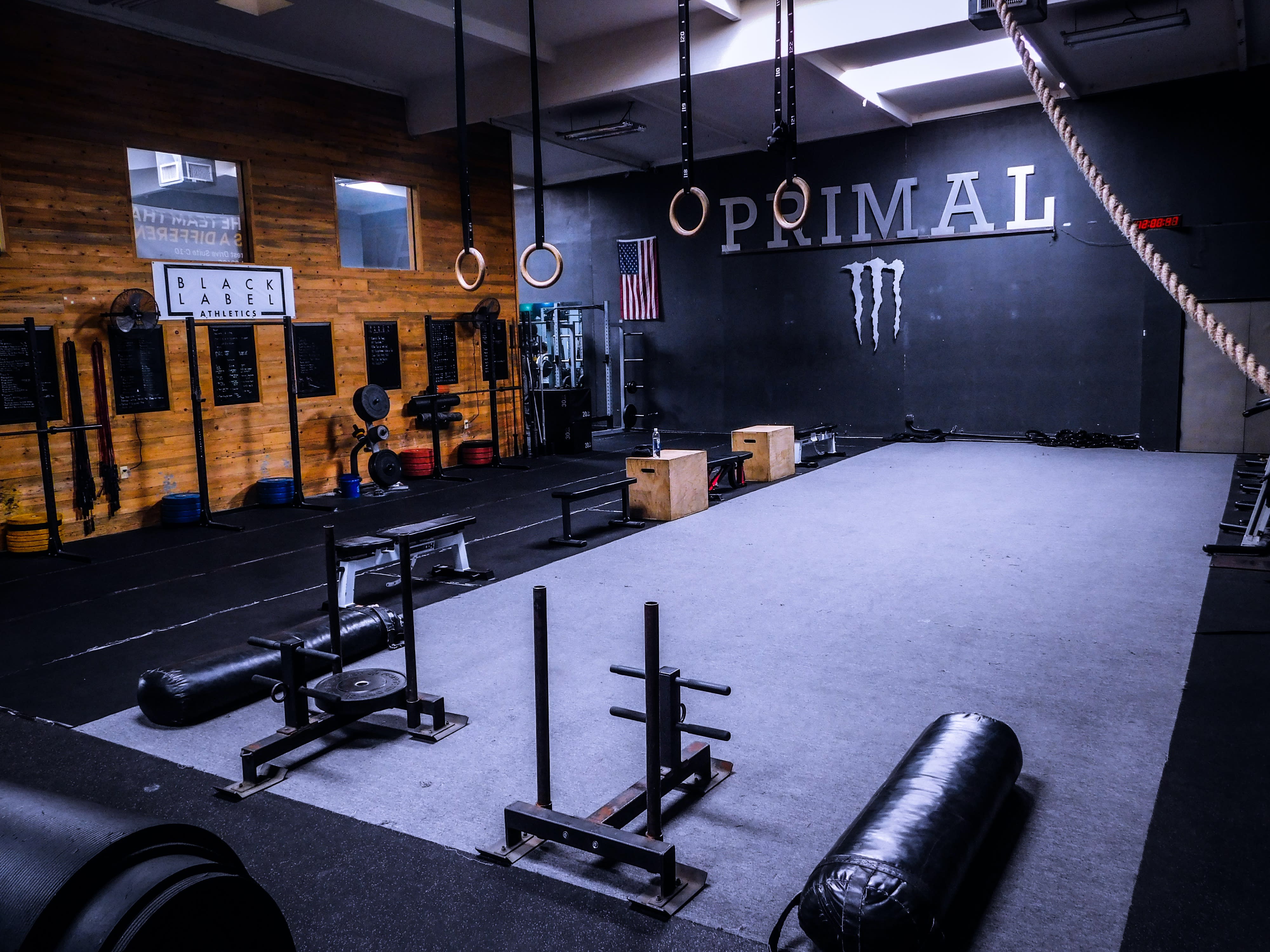 A muscular man poses in a gym setting during a video shoot.