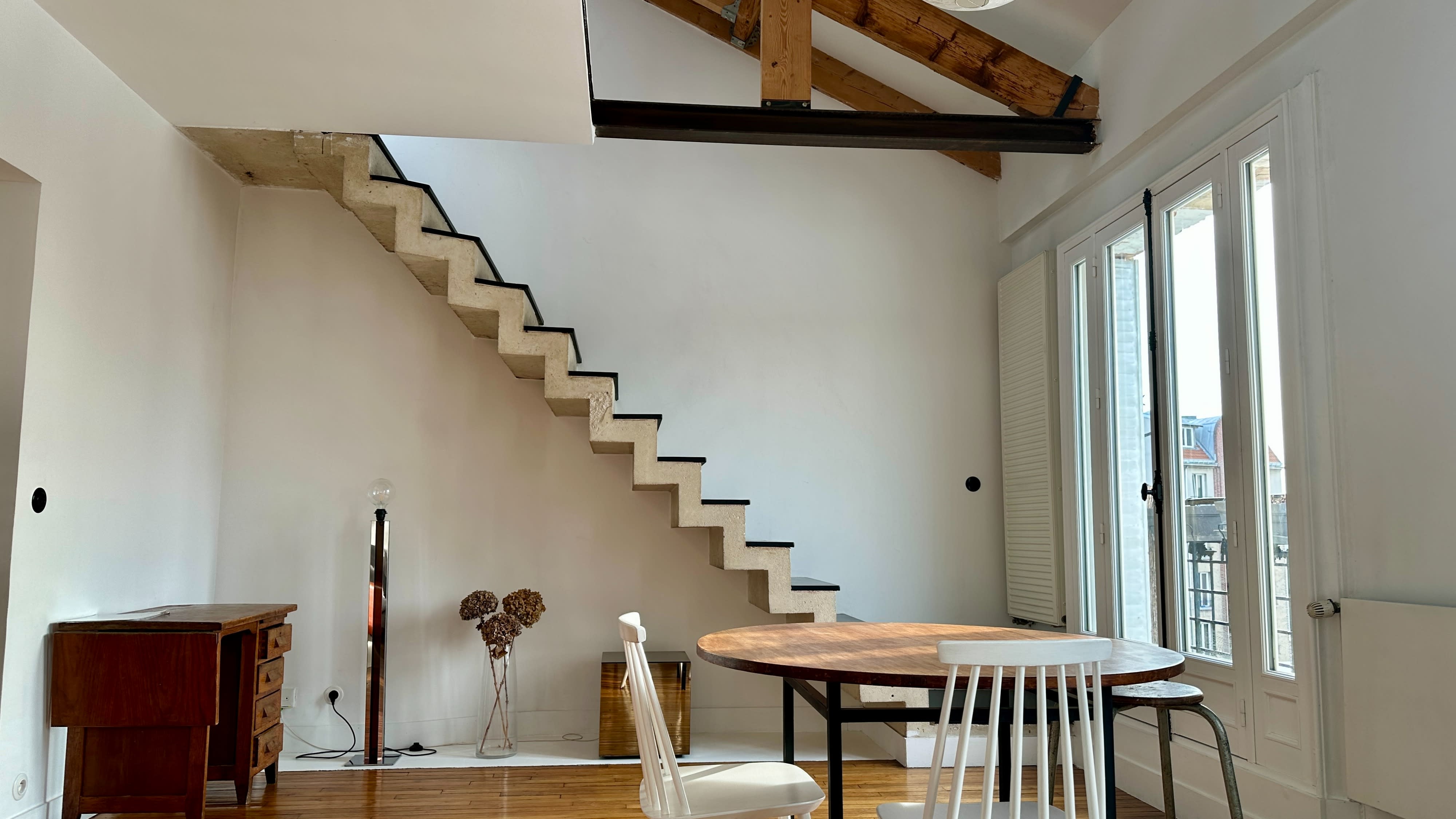A person descends a staircase while a cat stands at the bottom.
