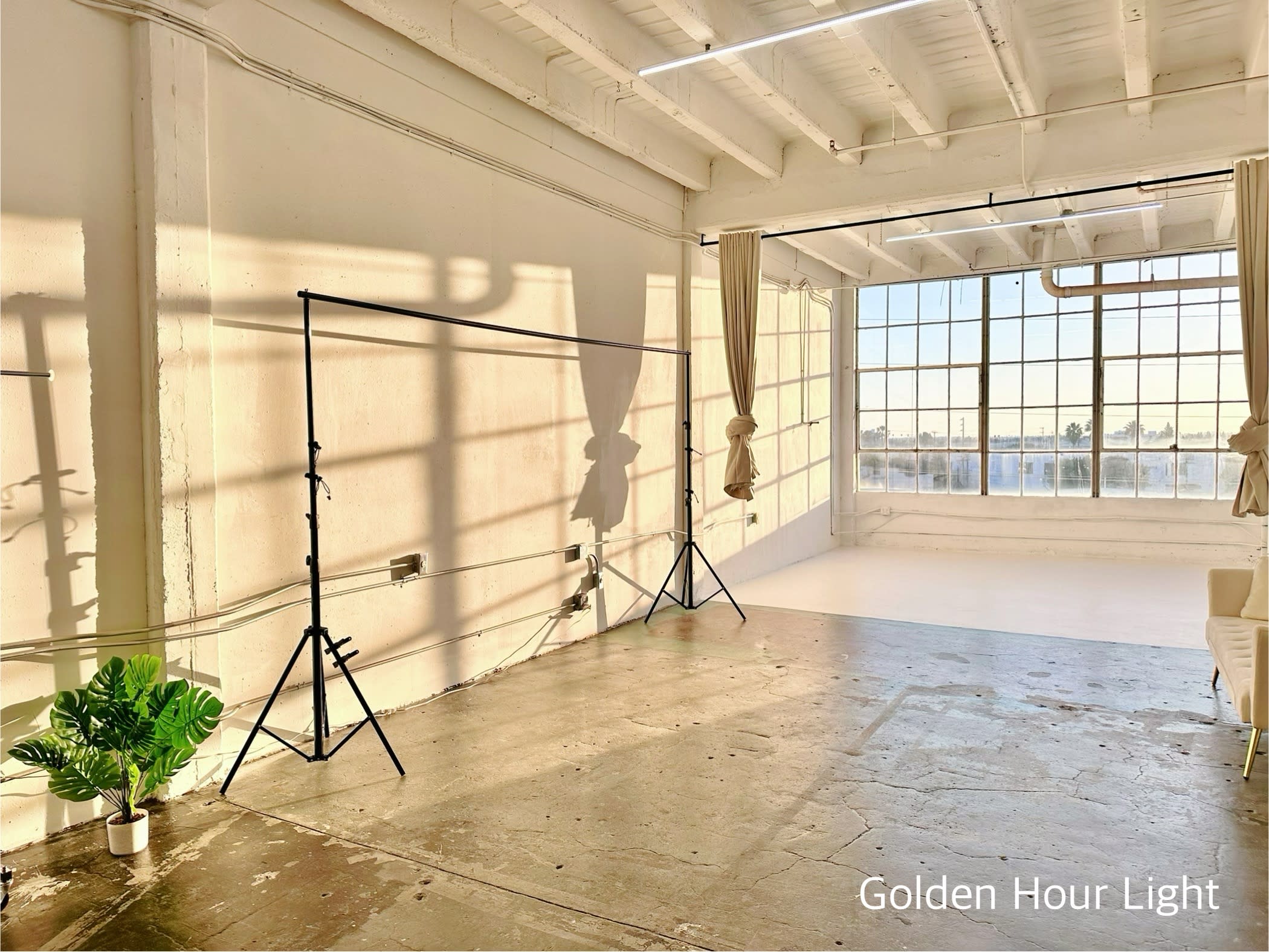 A woman seated on a yoga mat stretches her body forward while reaching for her toes in a bright, sunlit room.