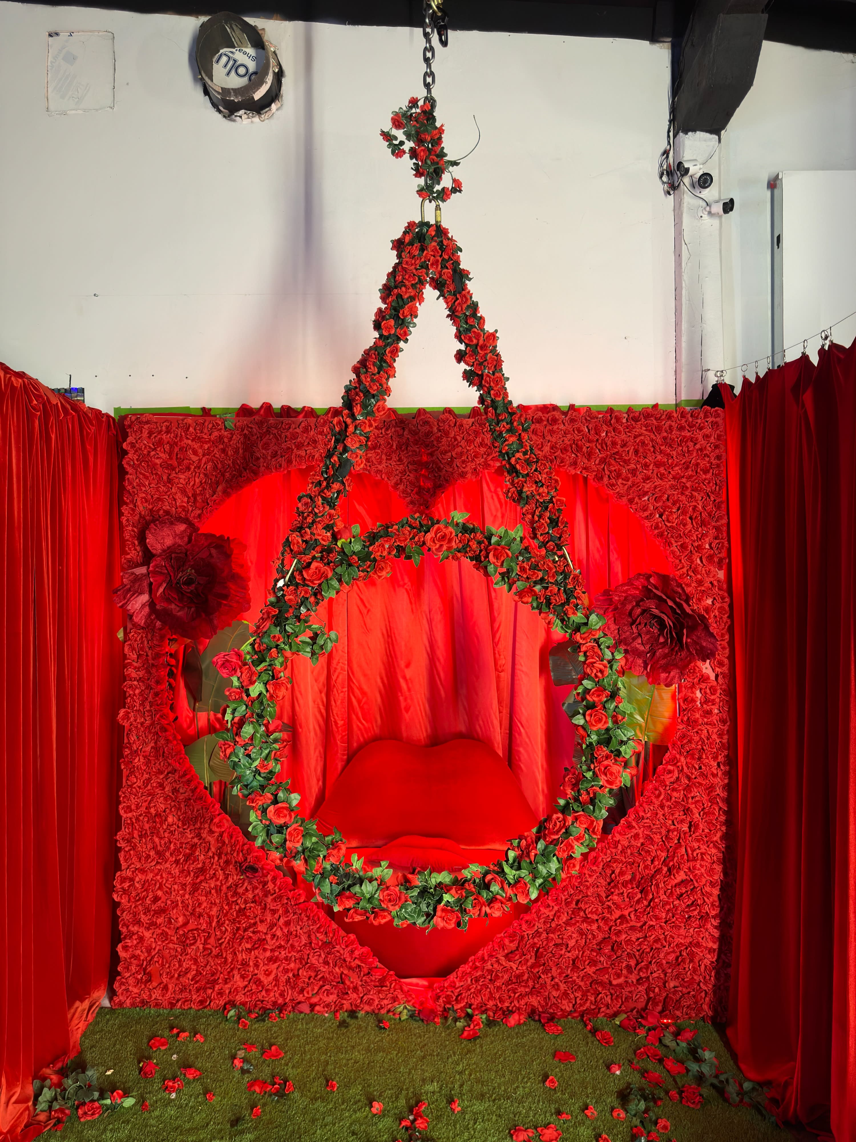 A couple poses together on a dark couch, framed by a gold mirror, showcasing their distinct styles during a photoshoot.