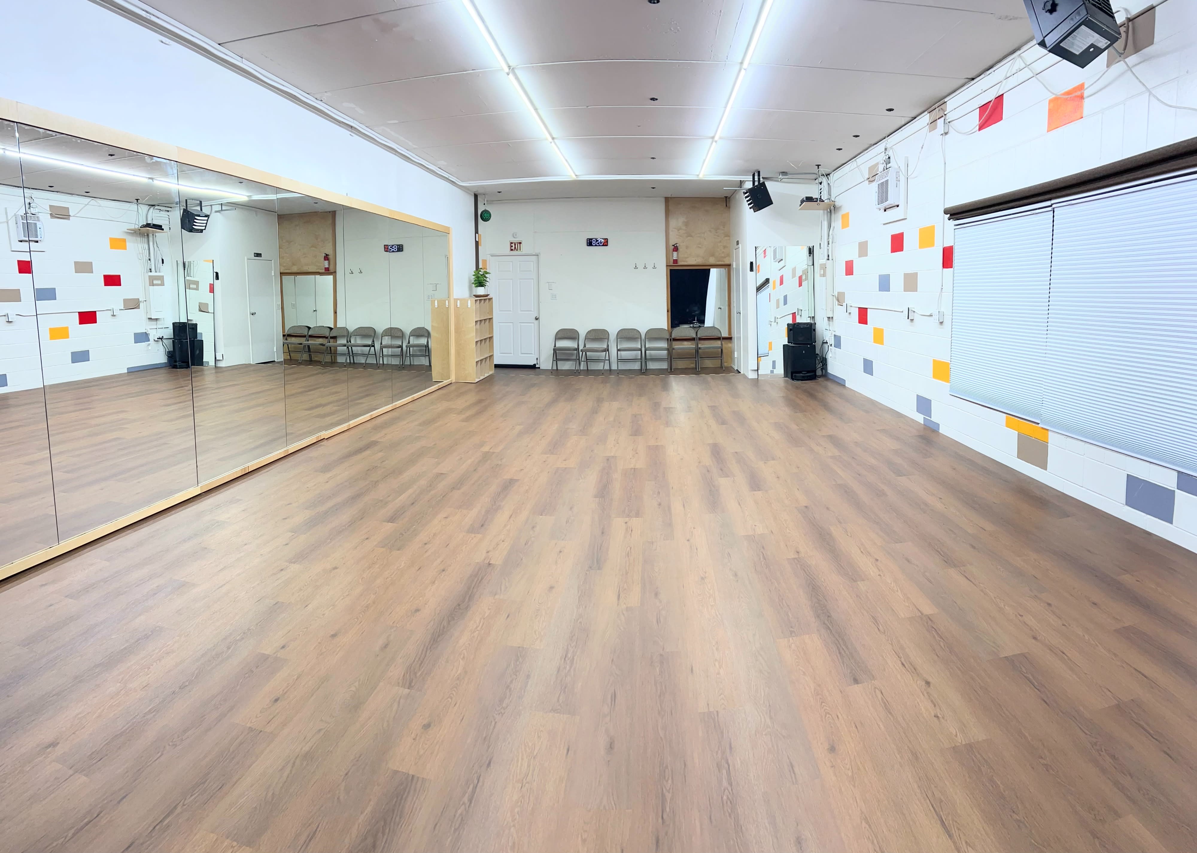 The image shows a photoshoot setup featuring a reflective background, lighting equipment, and a shiny floor surface.