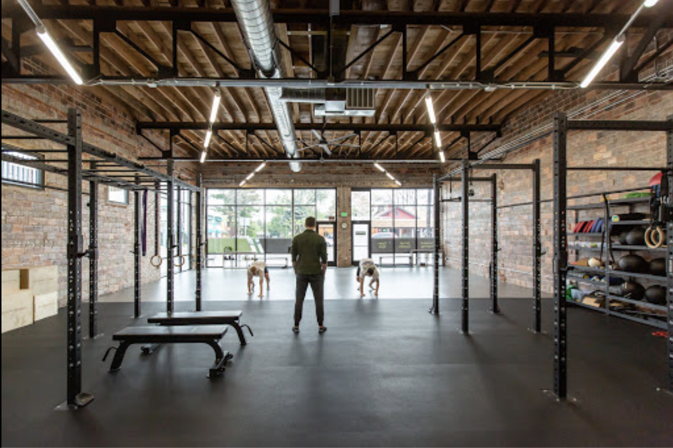 A person lifts a barbell during a fitness photo shoot in a gym setting.
