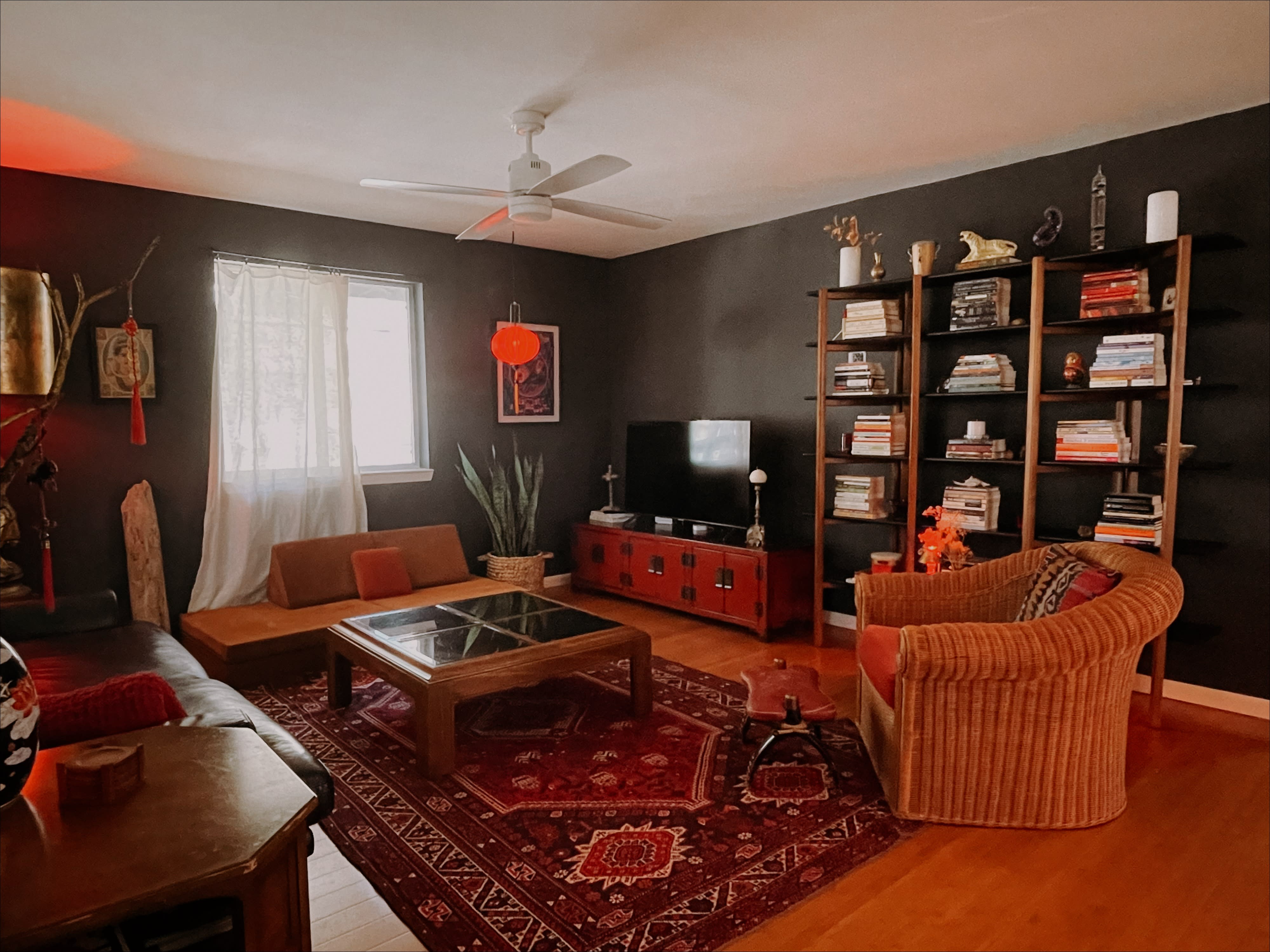 A filmed interview takes place in a living room setting, featuring multiple cameras focused on the interviewee, while crew members adjust lighting and equipment.