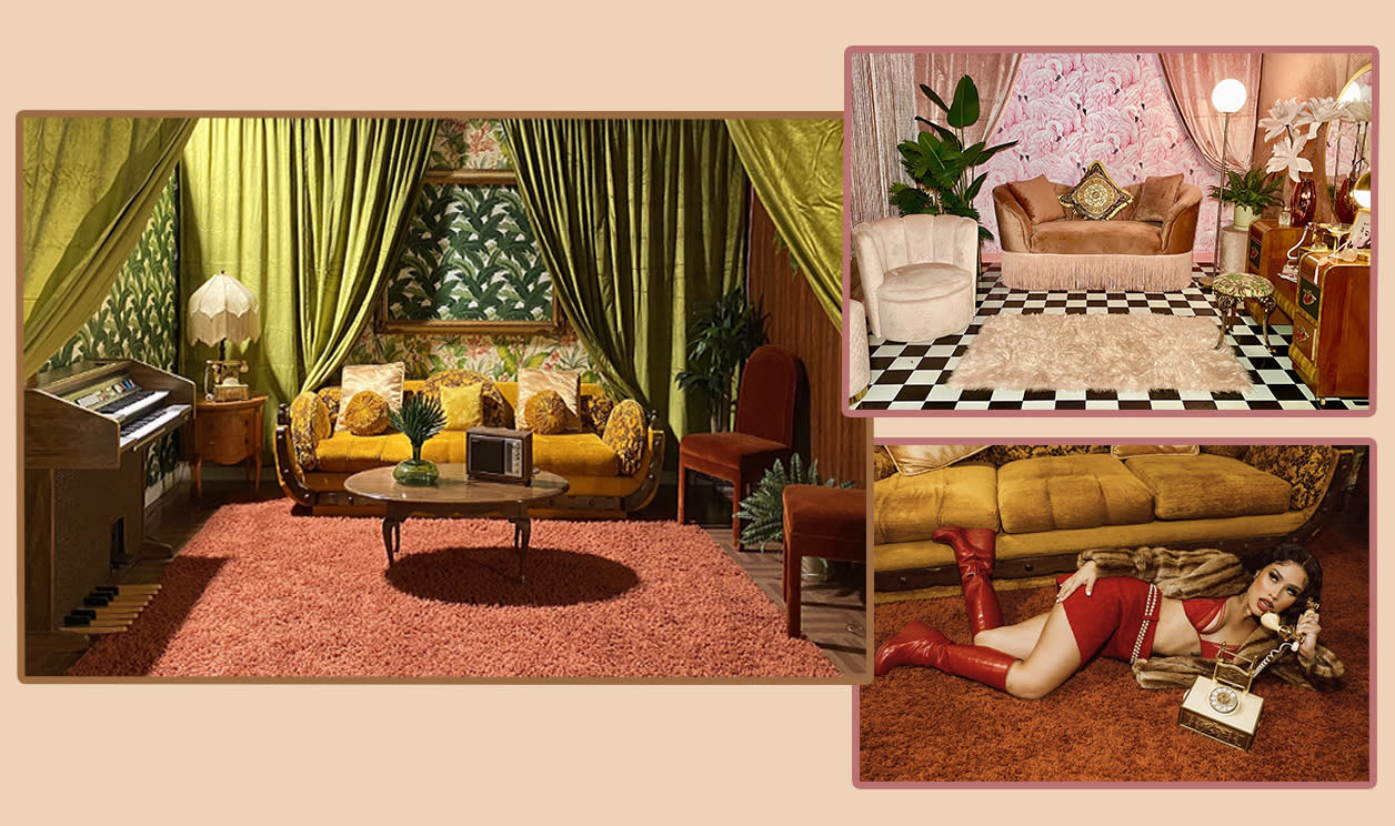 A vintage couch adorned with decorative pillows is set against a backdrop of floral wallpaper and greenery.