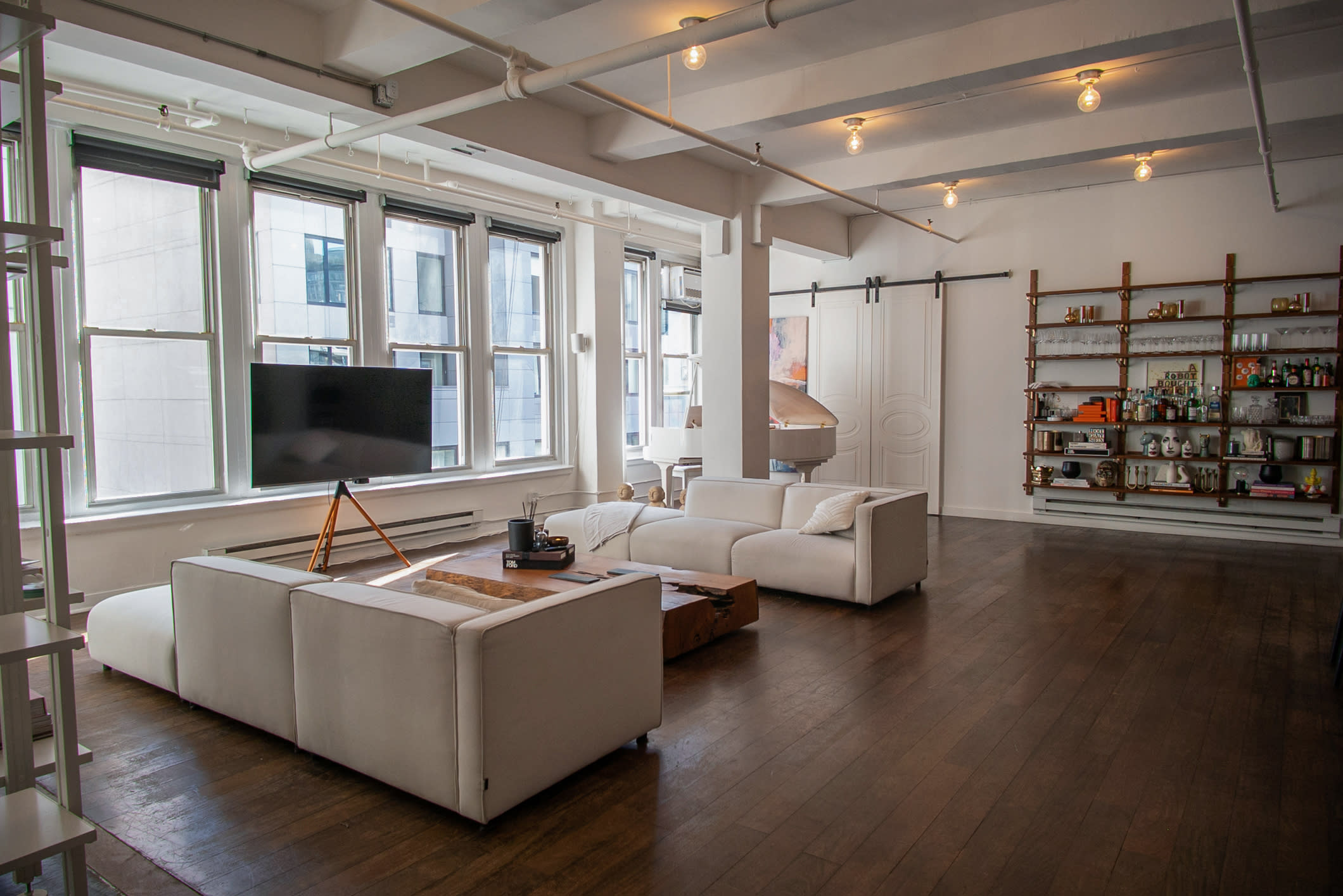 The room features a modern setup with white furniture and a TV, ready for an engagement party gathering.