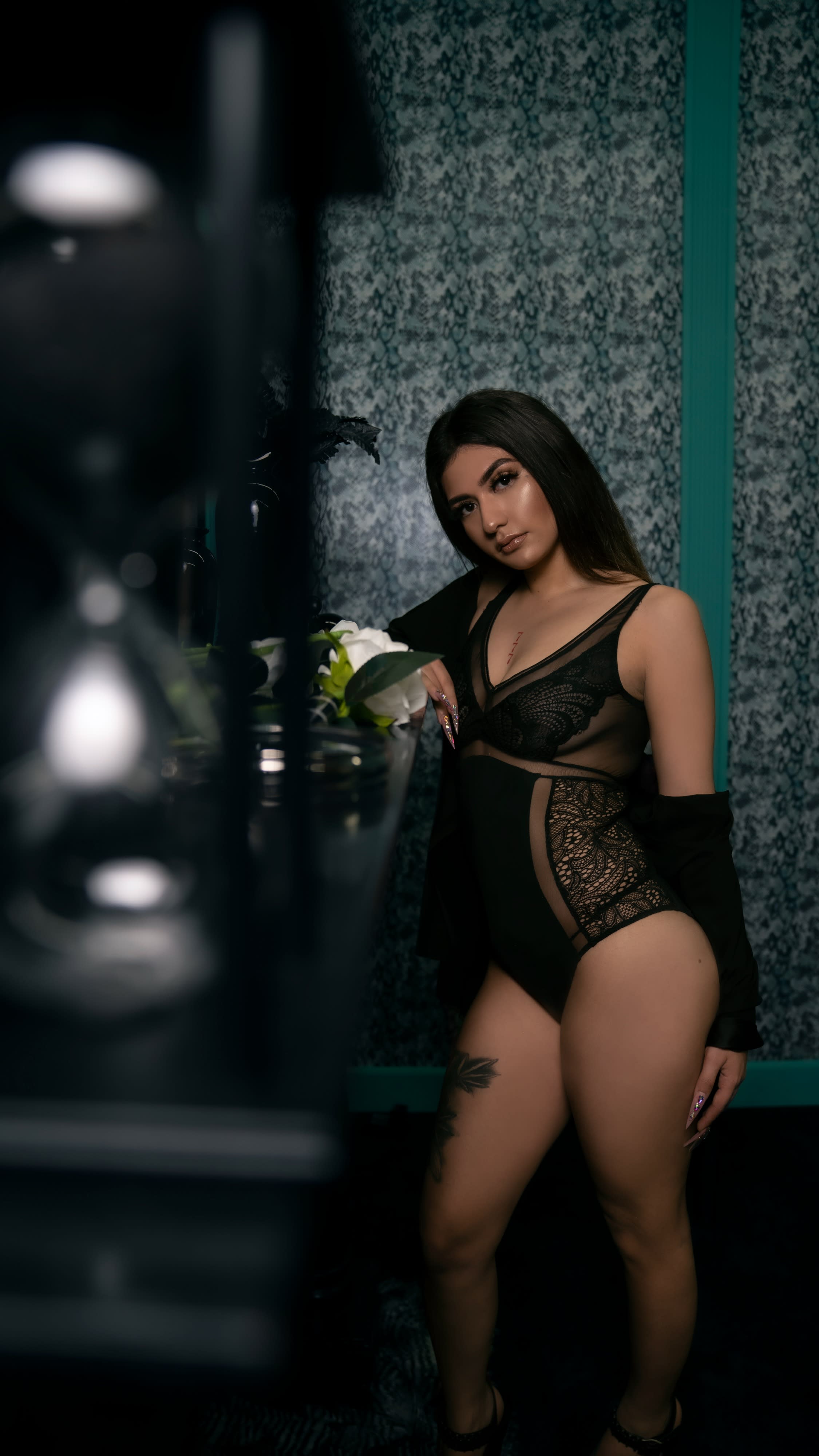 A model poses elegantly in a luxurious setting, showcasing a fashion shoot against a backdrop of ornate decor.