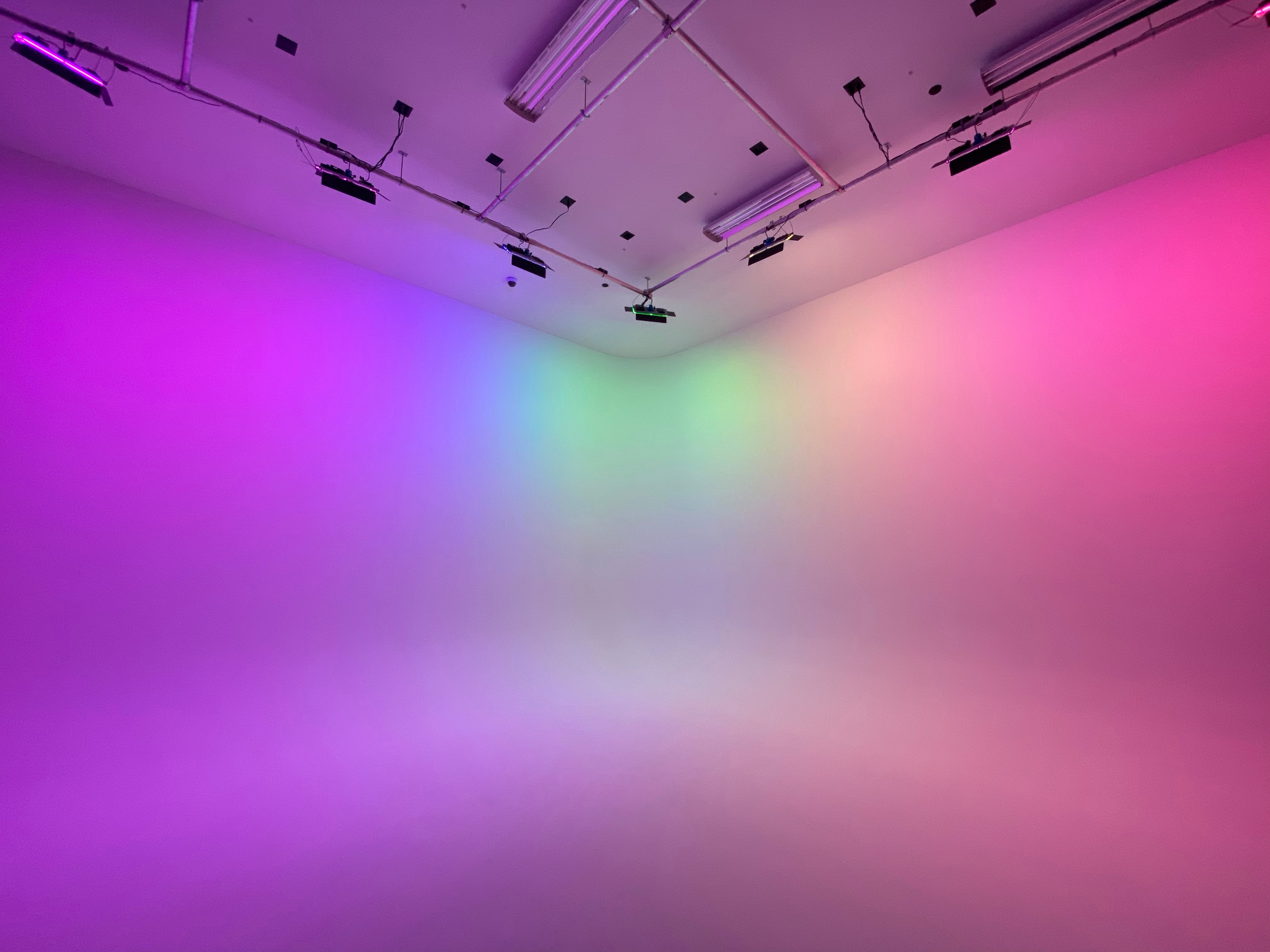 A camera is set up in a studio for a video shoot featuring a person seated in a well-lit space.
