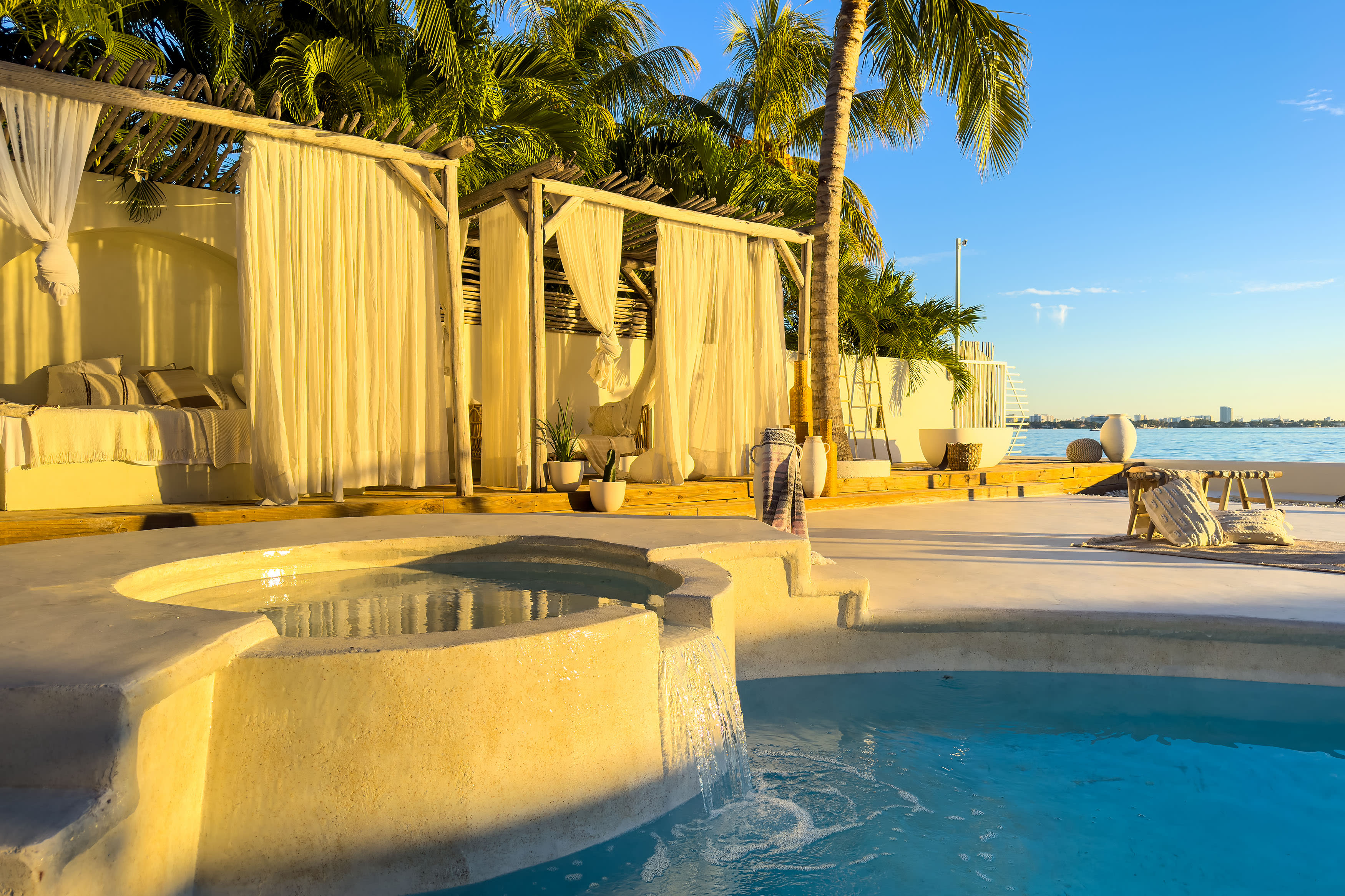 A model poses by a pool while a photographer adjusts the shot.