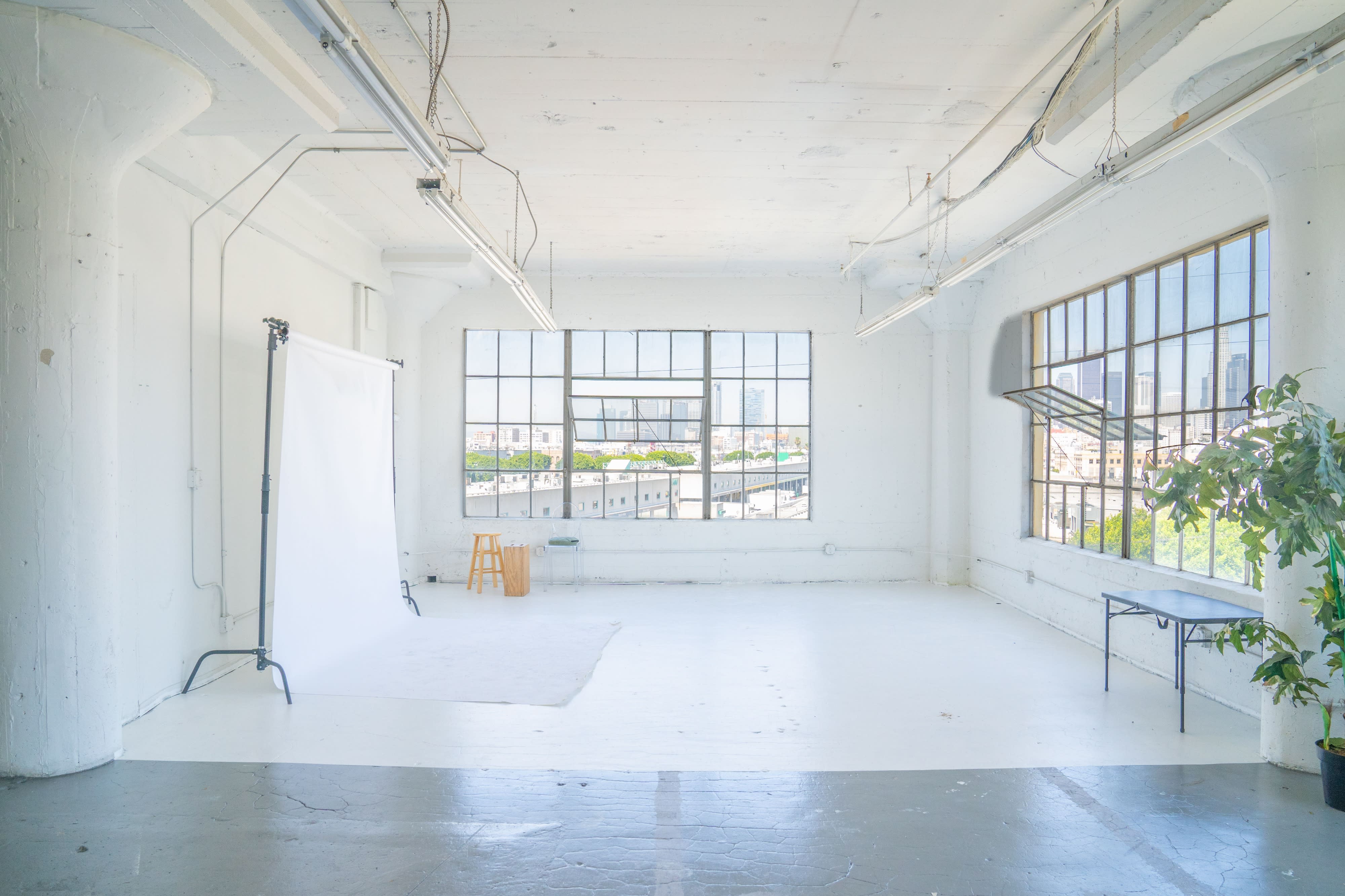 A person enjoys the sunlight while sitting in a bright, spacious room.
