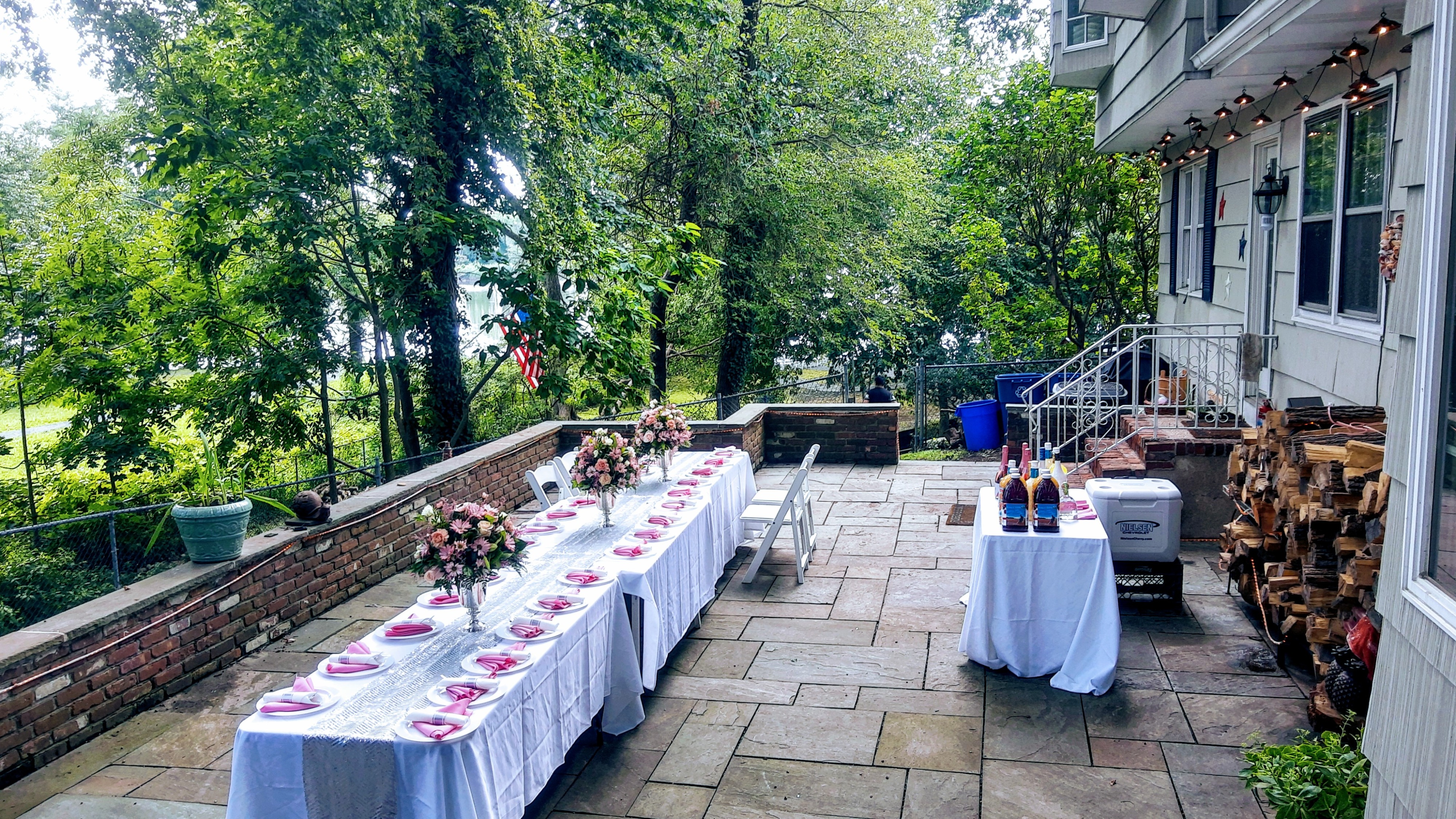 A bright sunroom is decorated with silver "50" balloons and a banner that reads "HAPPY BIRTHDAY," set against large windows overlooking a garden.