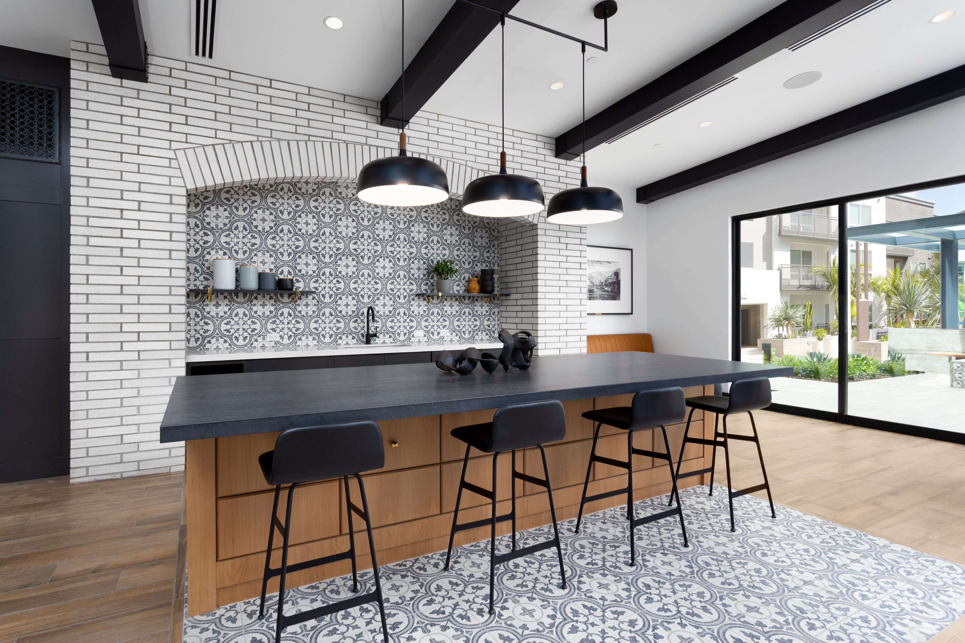 A decorated kitchen island features a variety of colorful food displays and a neon sign celebrating a birthday.