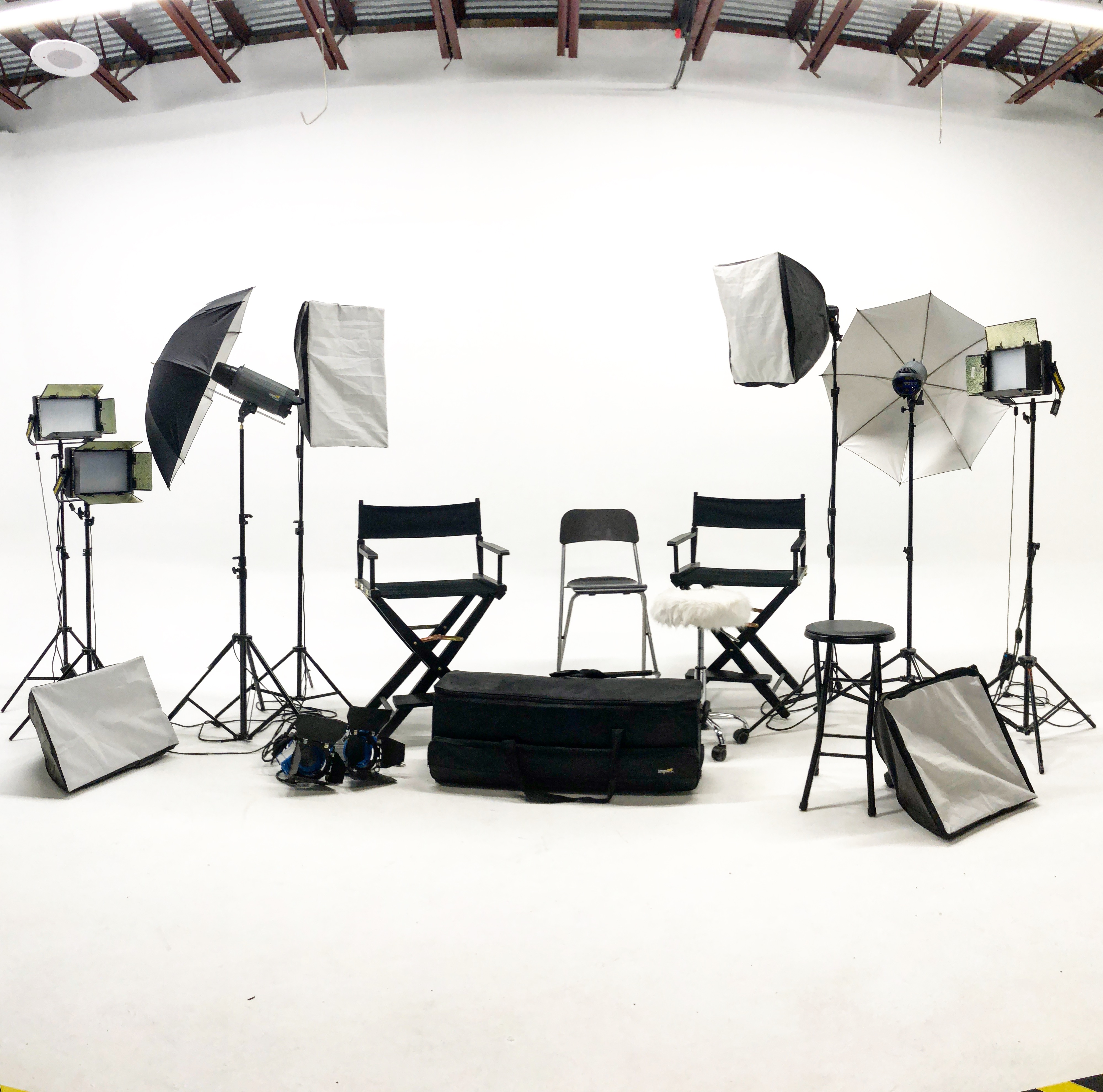 Three individuals are seated around a black table, engaged in a podcast recording with microphones and a laptop in front of them.