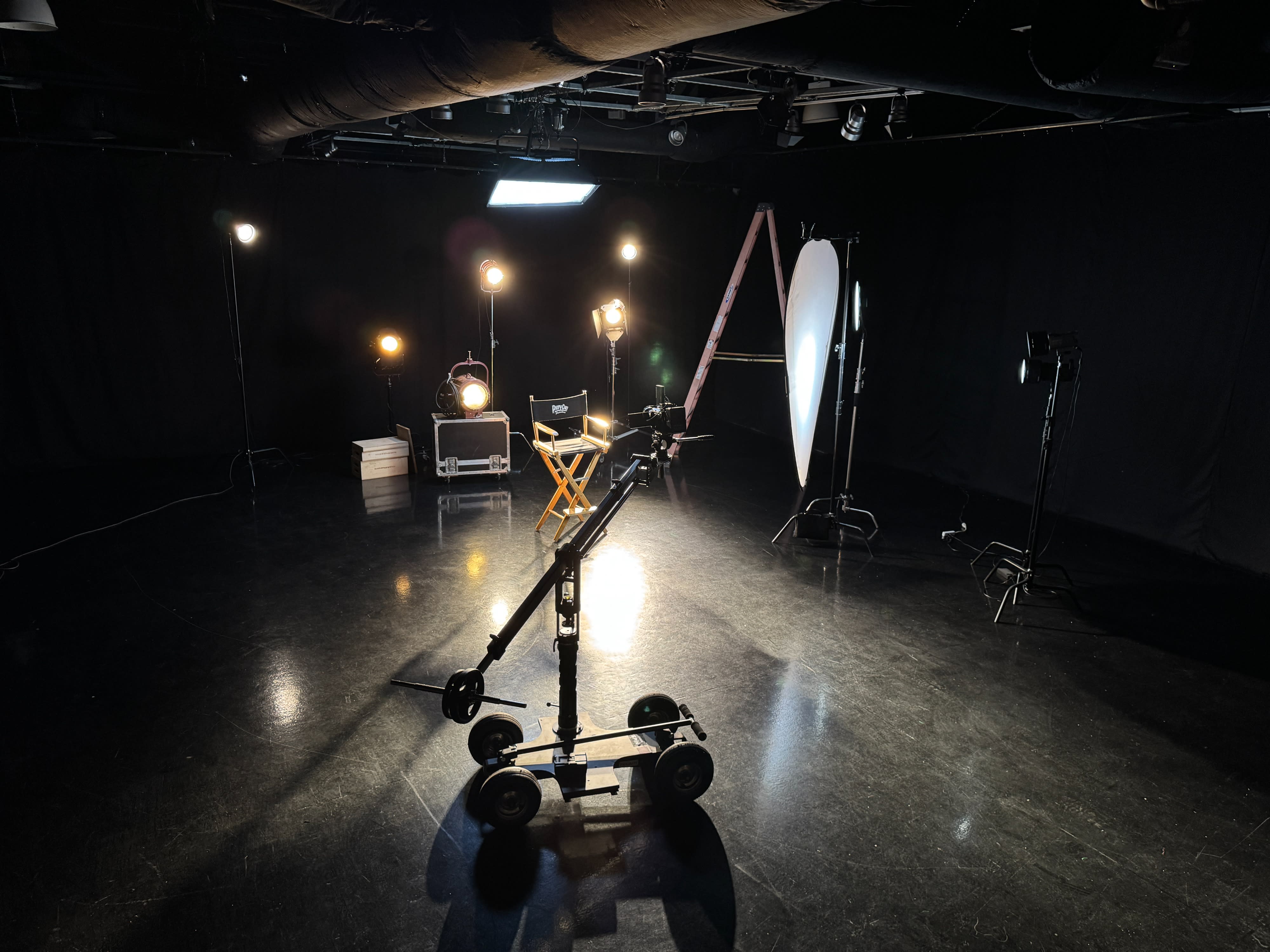 A band performs on stage with dramatic lighting, creating striking shadows as they play their instruments.