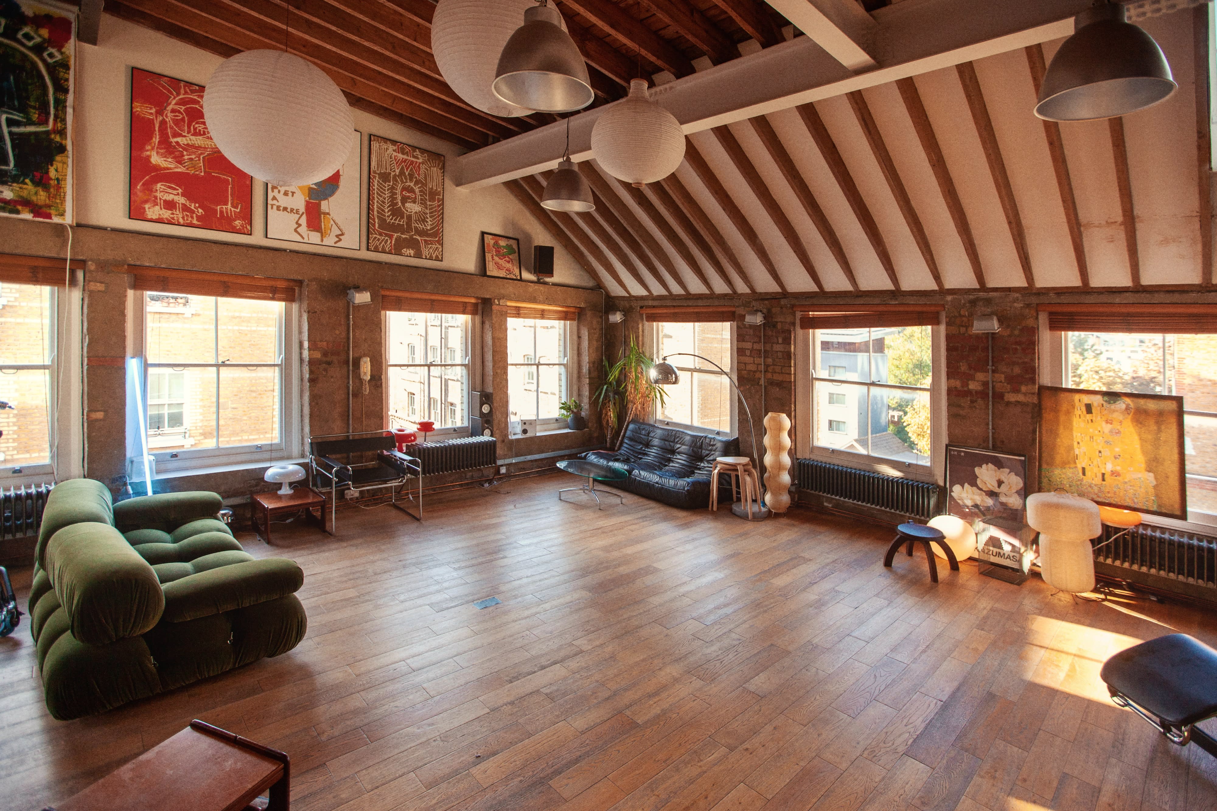 Two individuals are setting up a camera equipment for a video shoot in a decorated interior space.