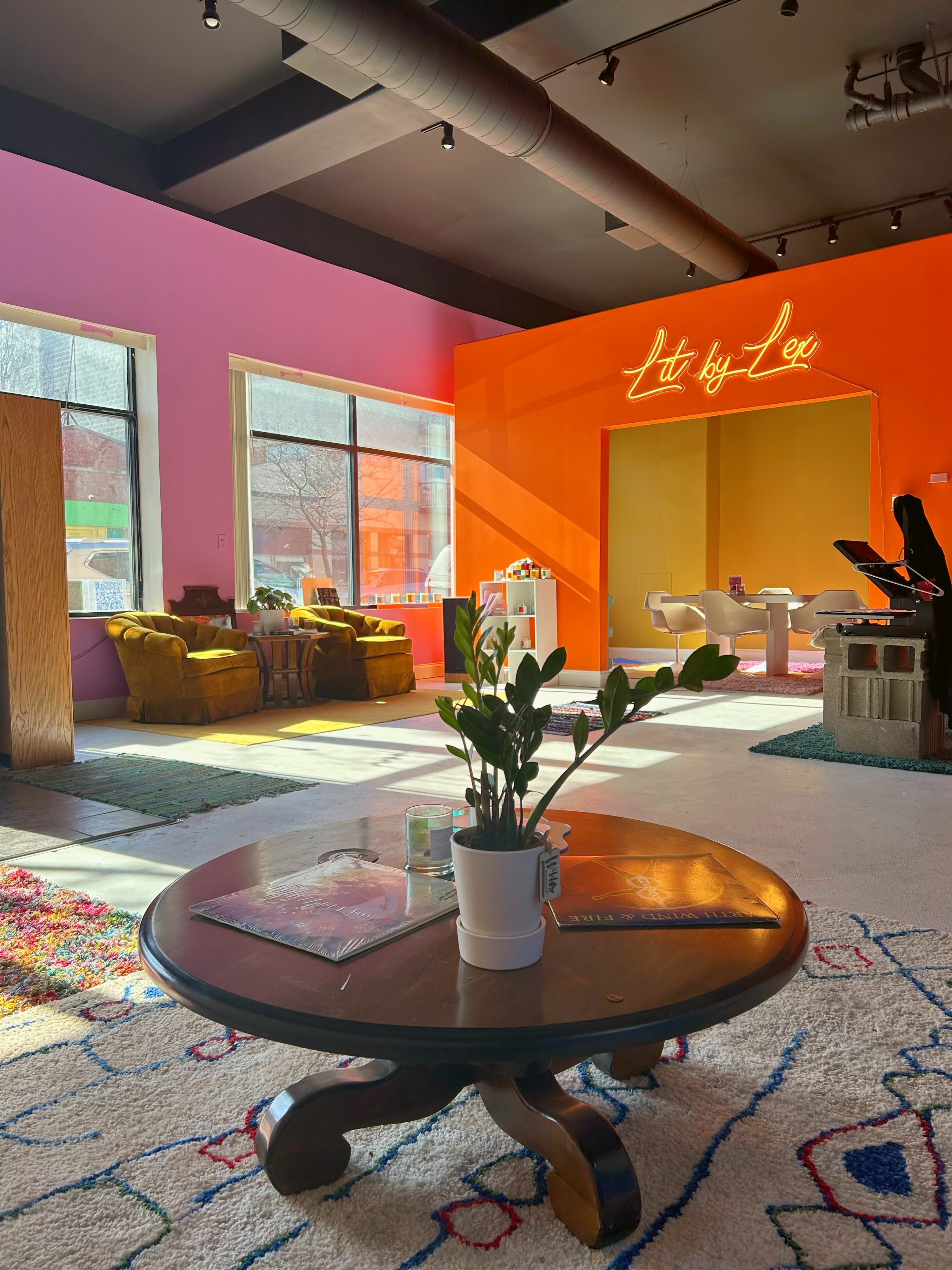 The room hosts a film screening with colorful walls and varied seating arrangements including chairs and couches.