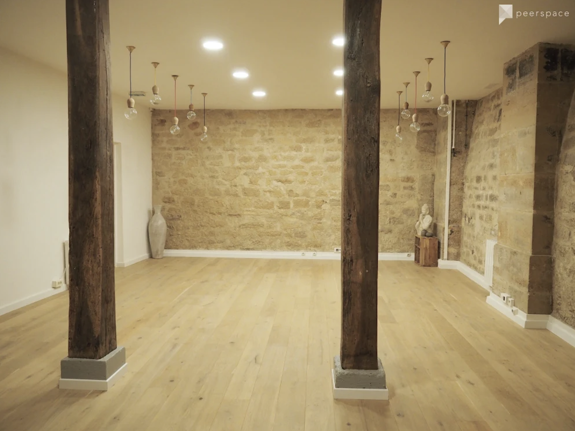 The wellness seminar space features several meditation cushions arranged on a wooden floor, surrounded by stone walls and soft lighting.