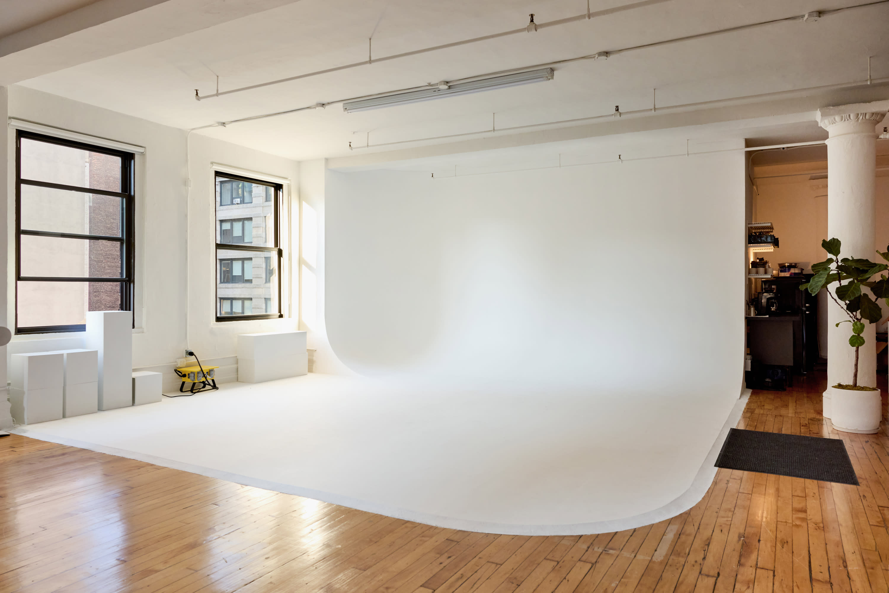 Participants engage in a photography workshop, capturing models posing on a white backdrop while seated and adjusting their cameras.